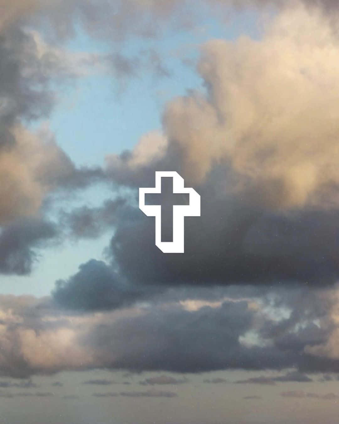 Aesthetic Jesus 桌布 壁紙 — 一個純白色的十字架在黃昏時分浮現於藍色和金色雲彩的戲劇性天空中。