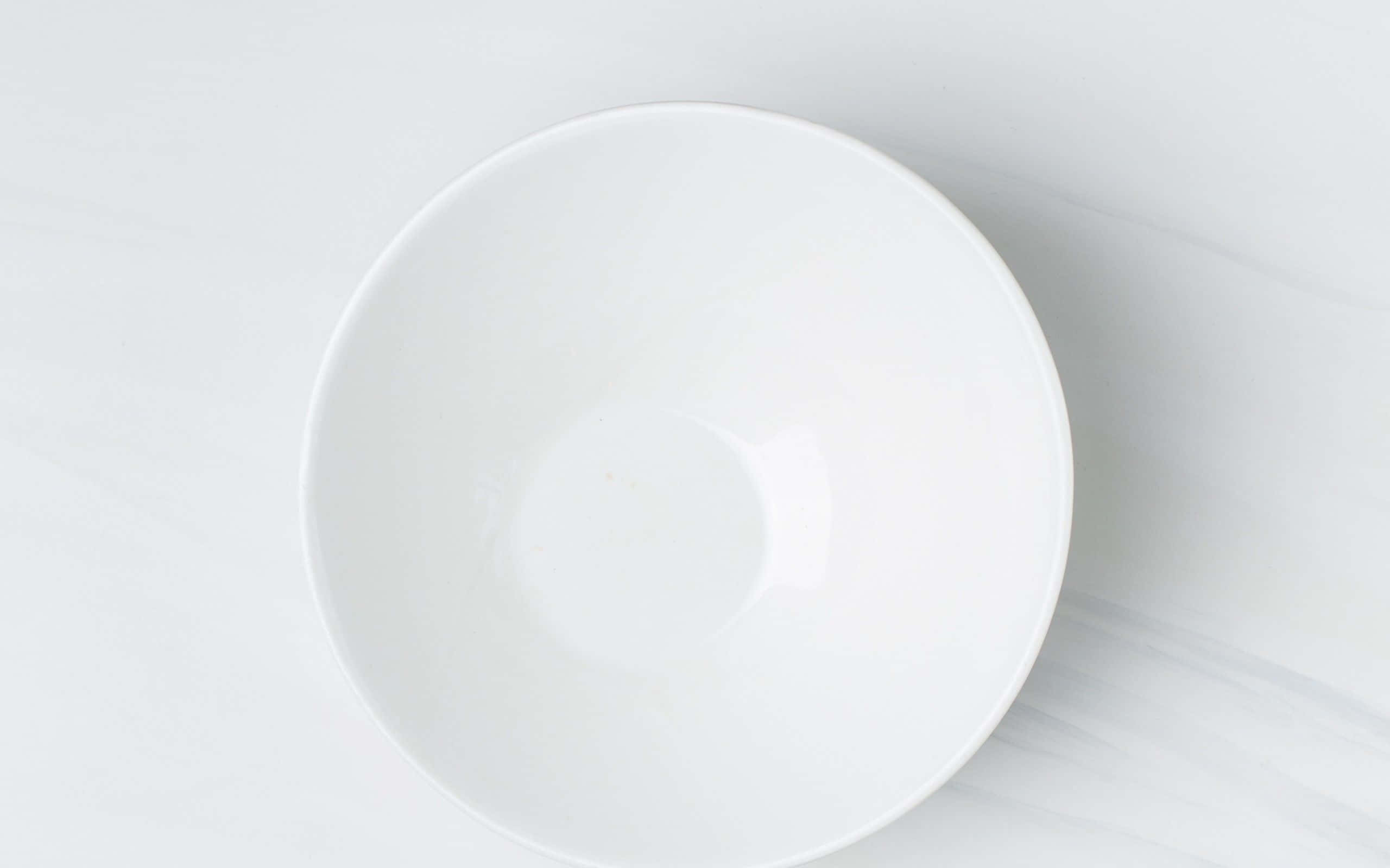 Ceramics 桌布 壁紙 — 一個純白色的陶瓷碗放在淺灰色大理石表面上，光線柔和擴散。