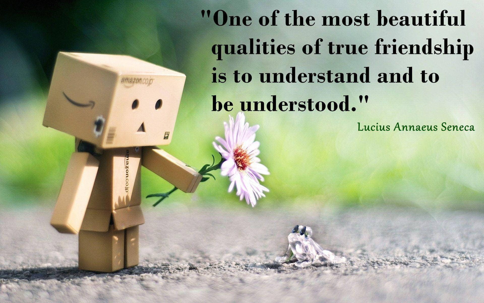 Friendship Quotes 桌布 壁紙 — 一個紙板Danbo公仔在碎石路上，溫柔地遞一朵紫色花給一隻小青蛙，背景是柔和的綠色。