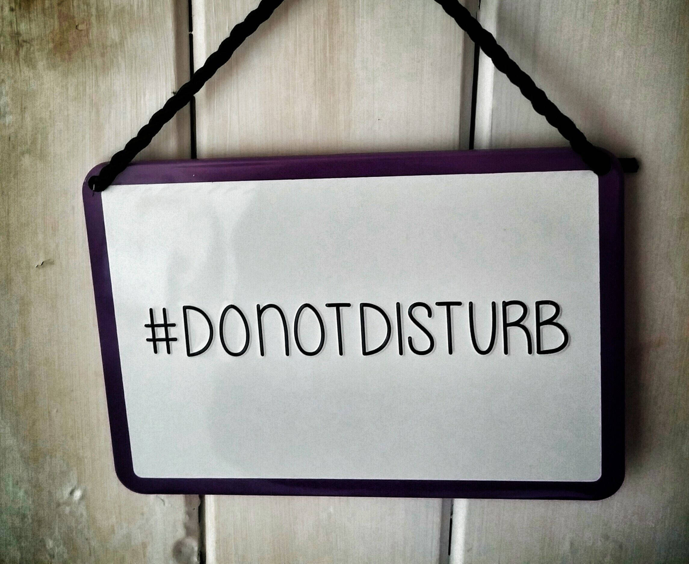 木紋 桌布 壁紙 — 一個紫色框的「#DONOTDISTURB」標誌用黑色繩子掛在風化的木門上。