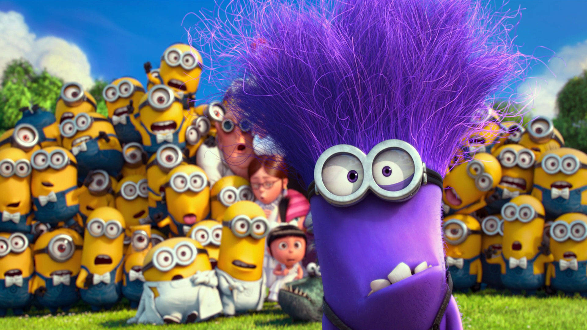 Despicable Me 2 桌布 壁紙 — 一個紫色頭髮的Minion戴著護目鏡站在前方，一群黃色Minion和人類在陽光明媚的草地上觀看。