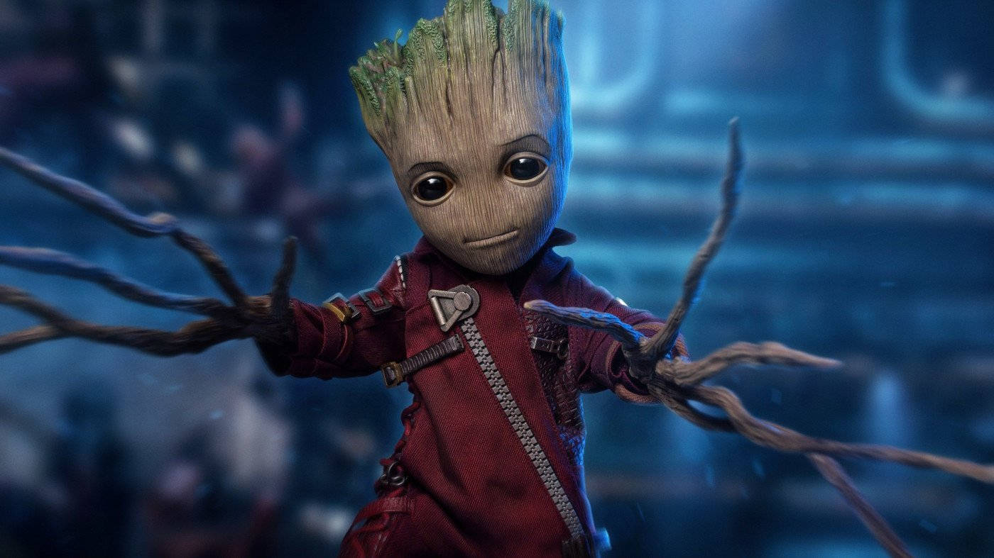 Baby Groot 桌布 壁紙 — 一個細小樹狀生物，有樹枝手臂和紅色外套，站在昏暗藍色科幻場景中。