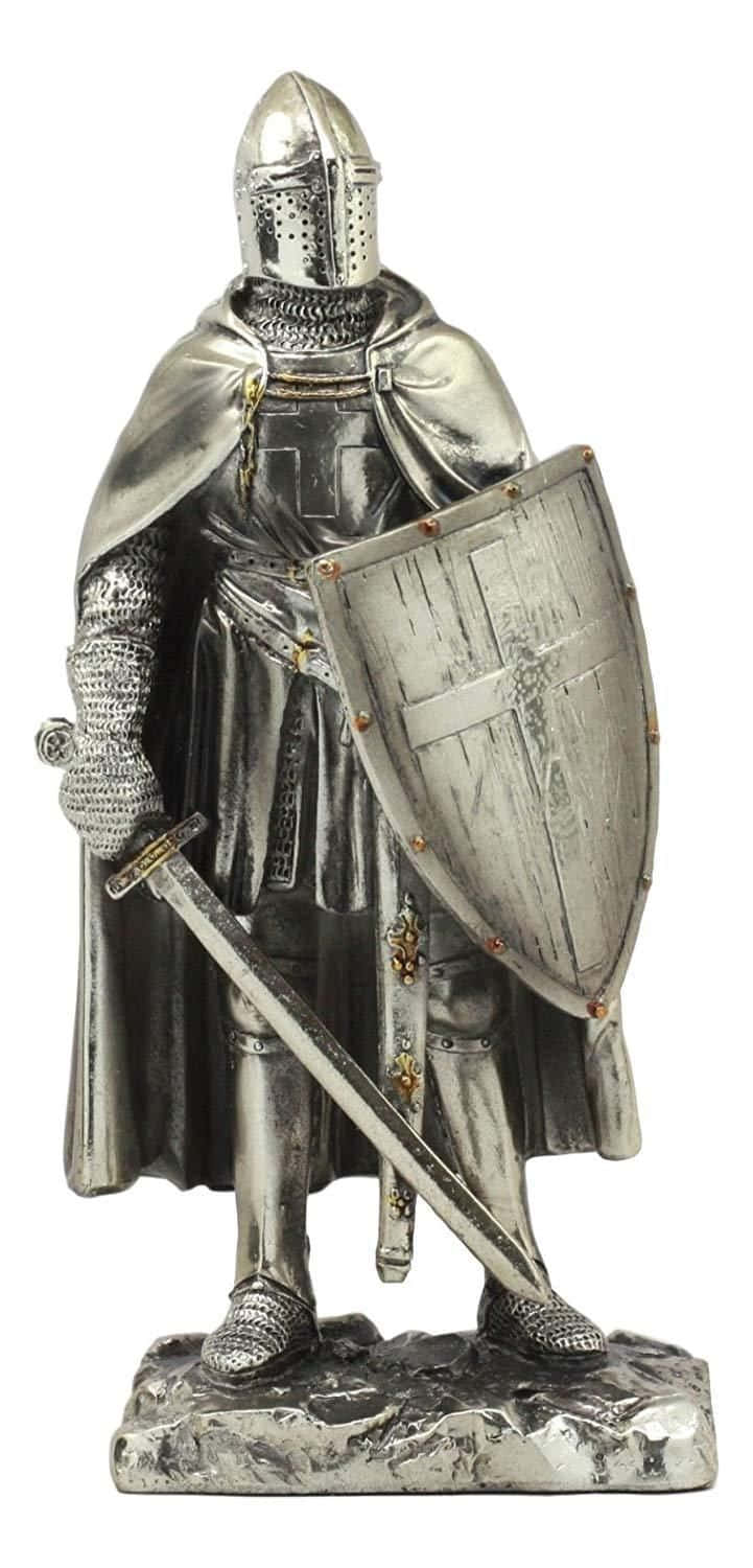 Crusader 桌布 壁紙 — 一個細節豐富的銀色騎士雕像，身穿全套盔甲，手持劍和盾牌，立於岩石底座上。