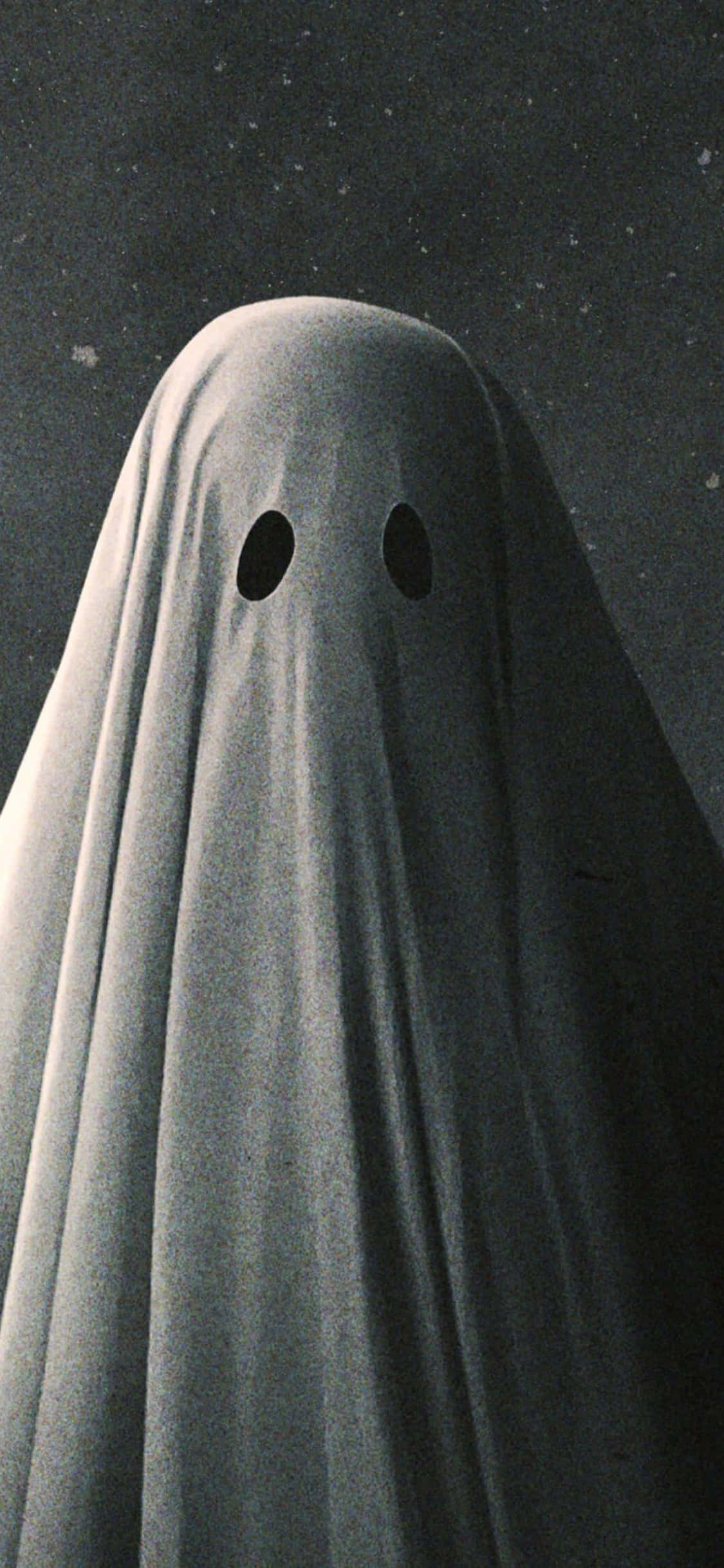 鬼魂 桌布 壁紙 — 一個經典的鬼魂形象，有兩個眼孔，凝視著繁星點點的夜空。