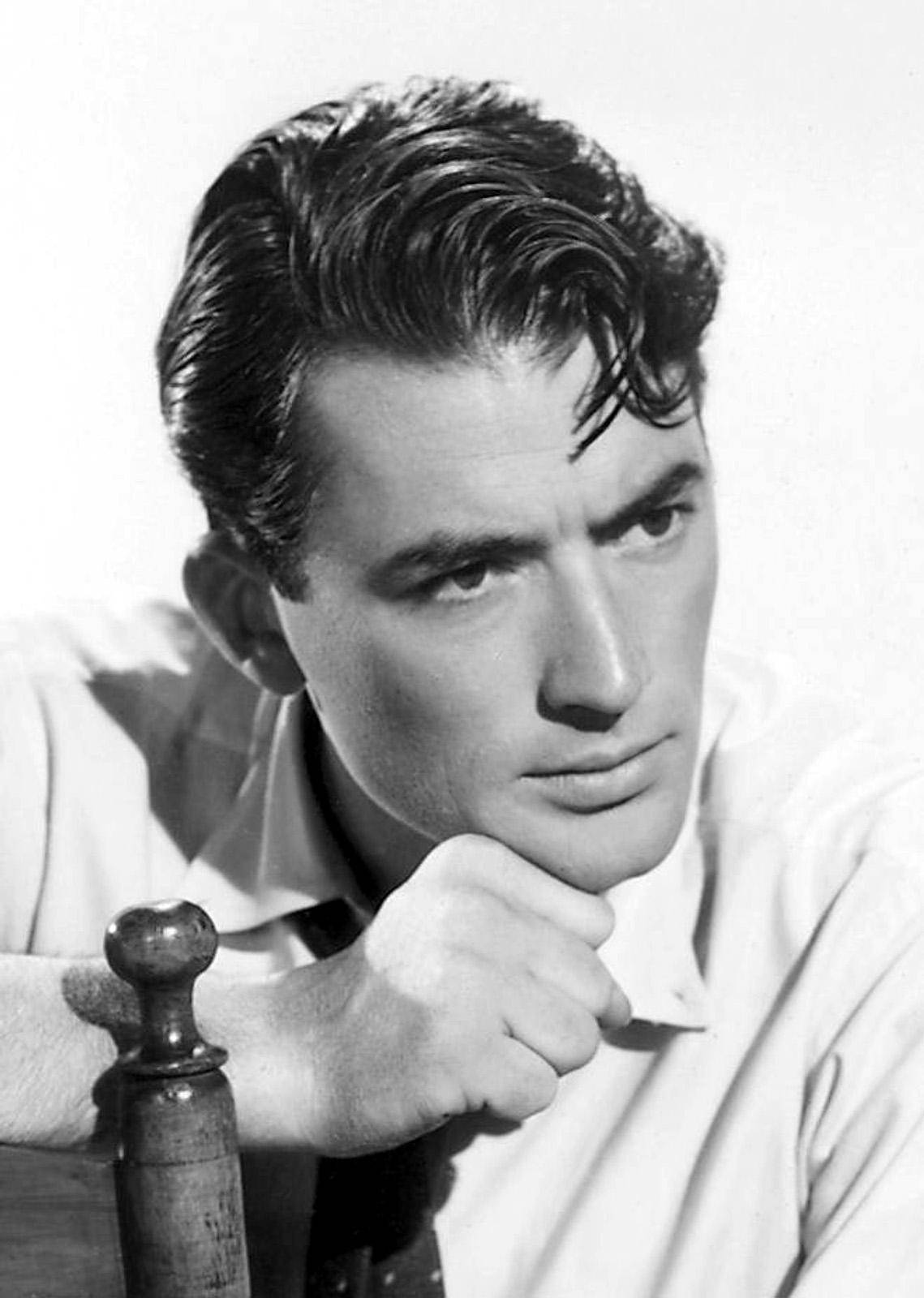 actor 桌布 壁紙 — 一個經典的黑白肖像，一個英俊的男人，頭髮造型，拳頭托腮，靠在木柱上。