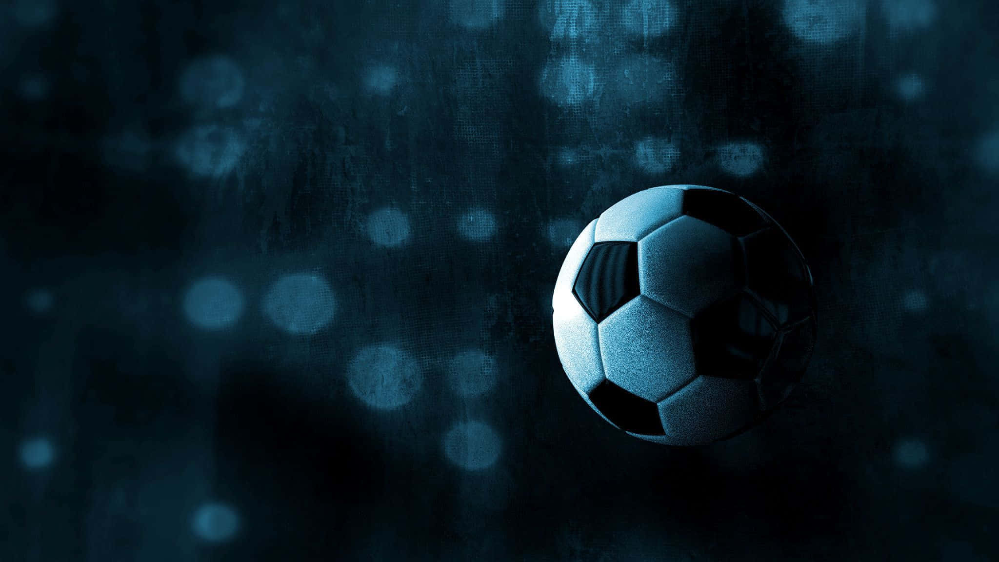 Soccer Aesthetic 桌布 壁紙 — 一個經典的黑白足球在冷藍光下發光，背景是帶有柔和散景圓圈的紋理深色背景。