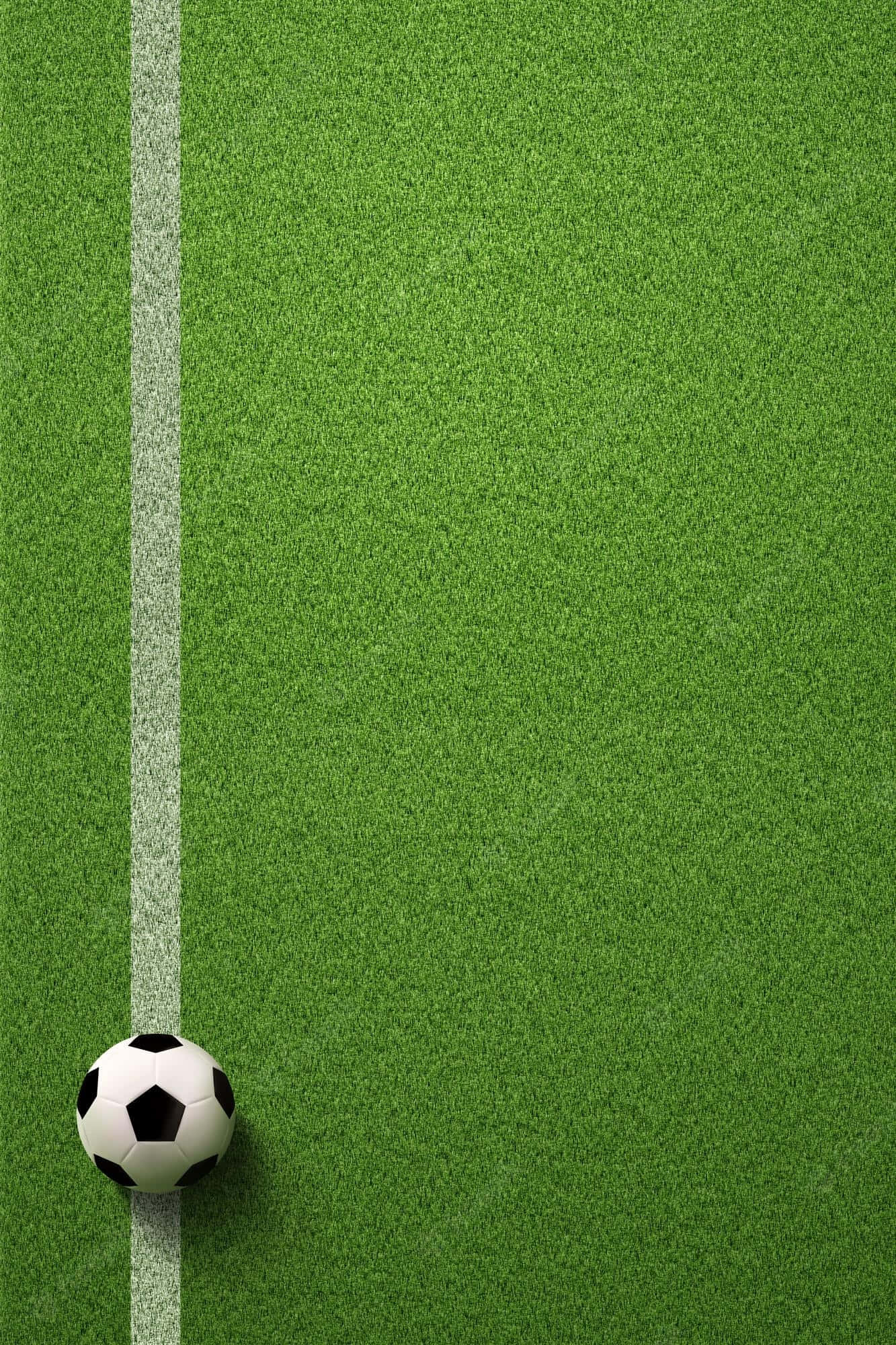 Football Field 桌布 壁紙 — 一個經典的黑白足球放在一個充滿活力的綠色人造草地球場的角落，由一條清晰的白色線標記。