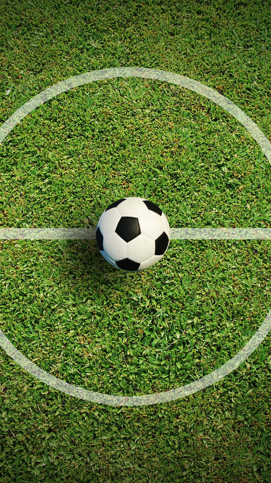 Soccer iPhone 桌布 壁紙 — 一個經典的黑白足球放在一個充滿活力的綠色草地上，草地有清晰的白色界線。