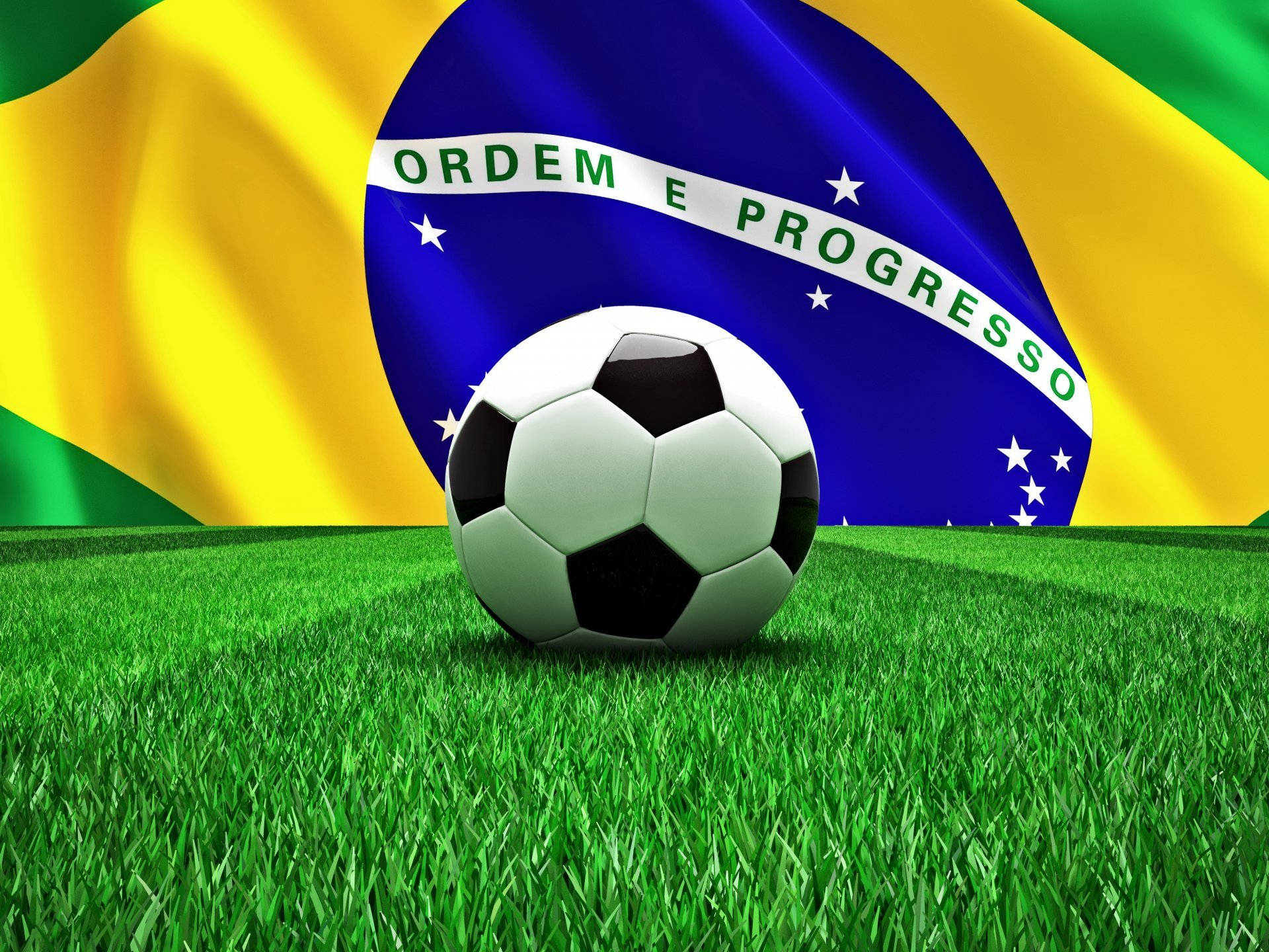 Brazil Flag 桌布 壁紙 — 一個經典的黑白足球放在充滿活力的綠色草地上，背景是飄揚的巴西國旗。
