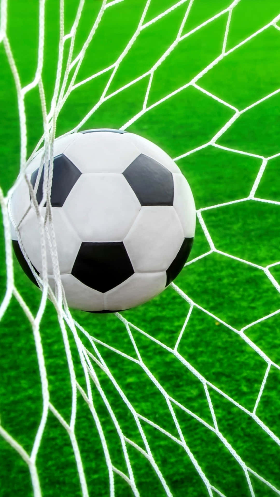 Soccer iPhone 桌布 壁紙 — 一個經典的黑白足球放在白色網內，背景是充滿活力的綠色球場。