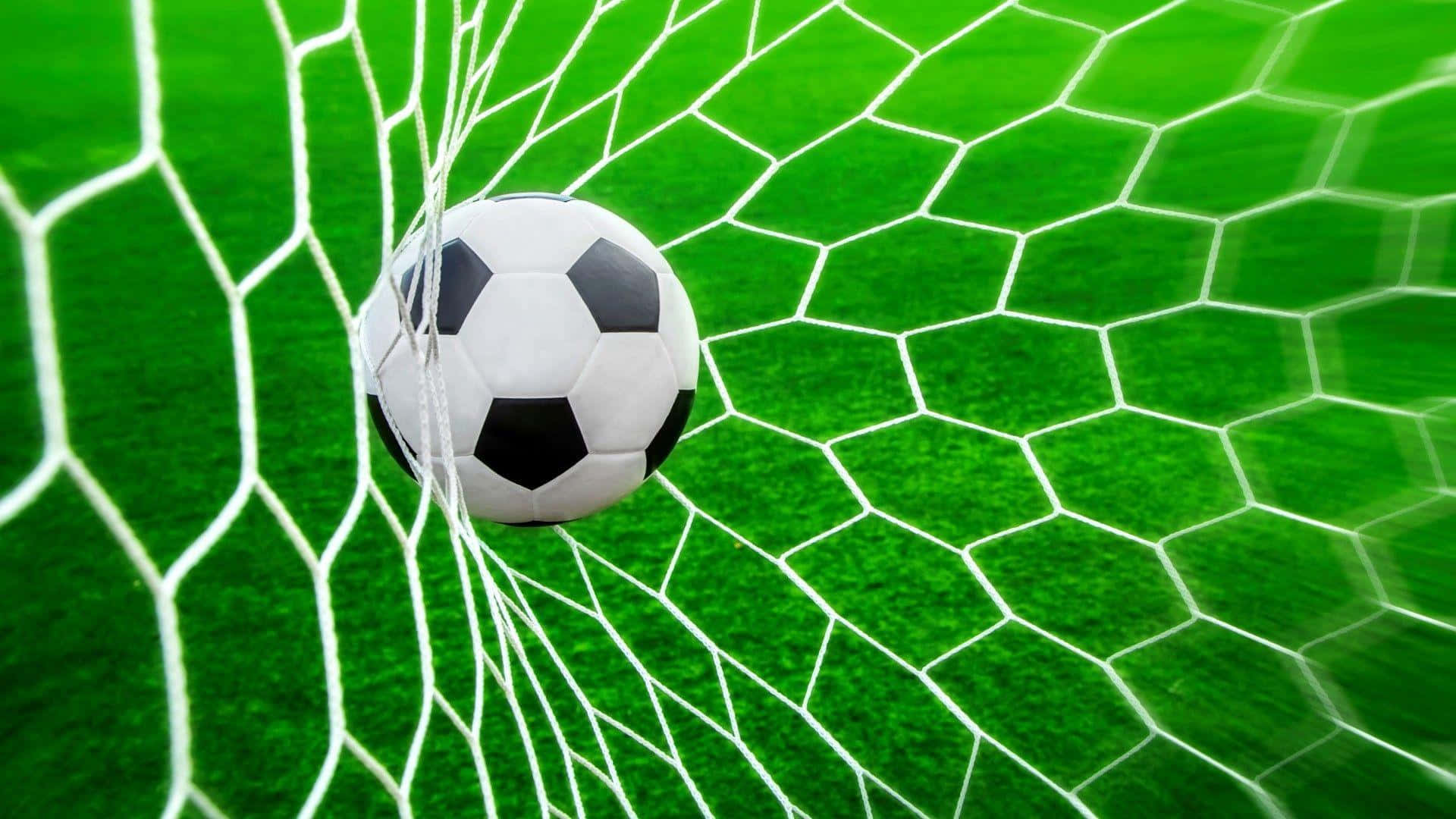 Soccer Ball 桌布 壁紙 — 一個經典的黑白足球放在白色網內，背景是充滿活力的綠色球場。