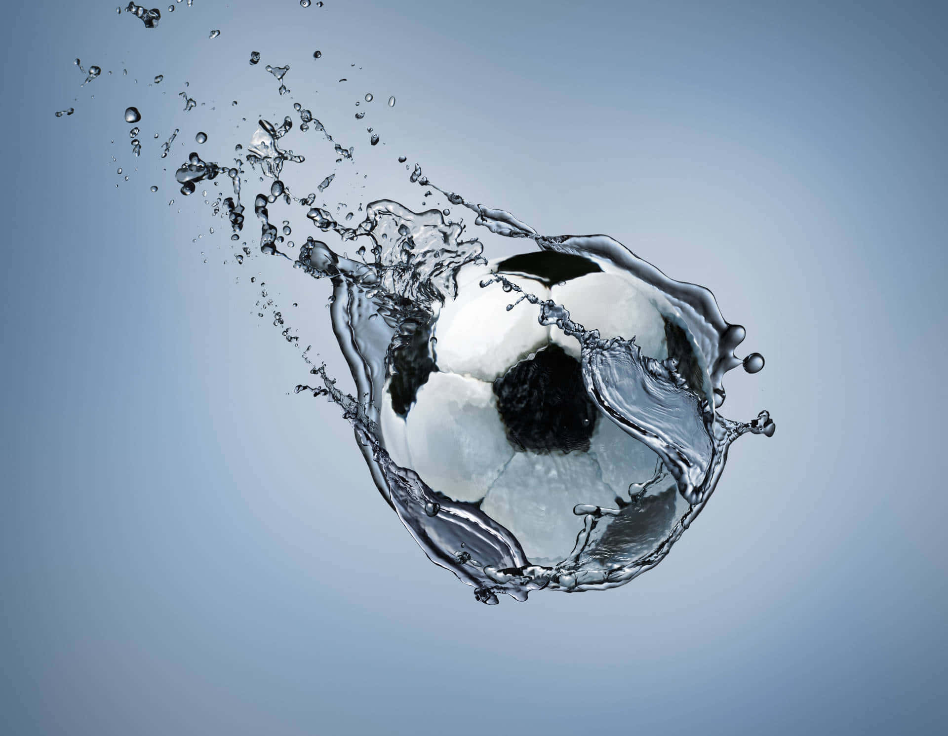 Soccer Ball 桌布 壁紙 — 一個經典的黑白足球衝破水面，在柔和的藍色漸變背景上產生動態水花。