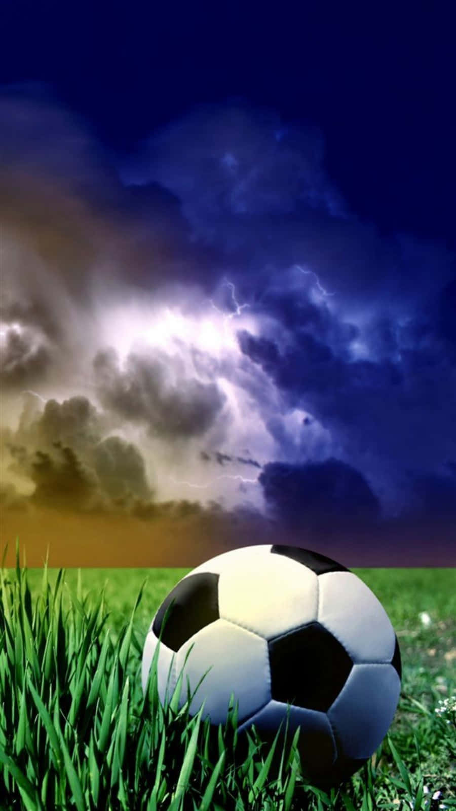 Soccer Ball 桌布 壁紙 — 一個經典足球放在充滿活力的綠色草地上，下方是帶有鮮明閃電的戲劇性暴風雨天空。