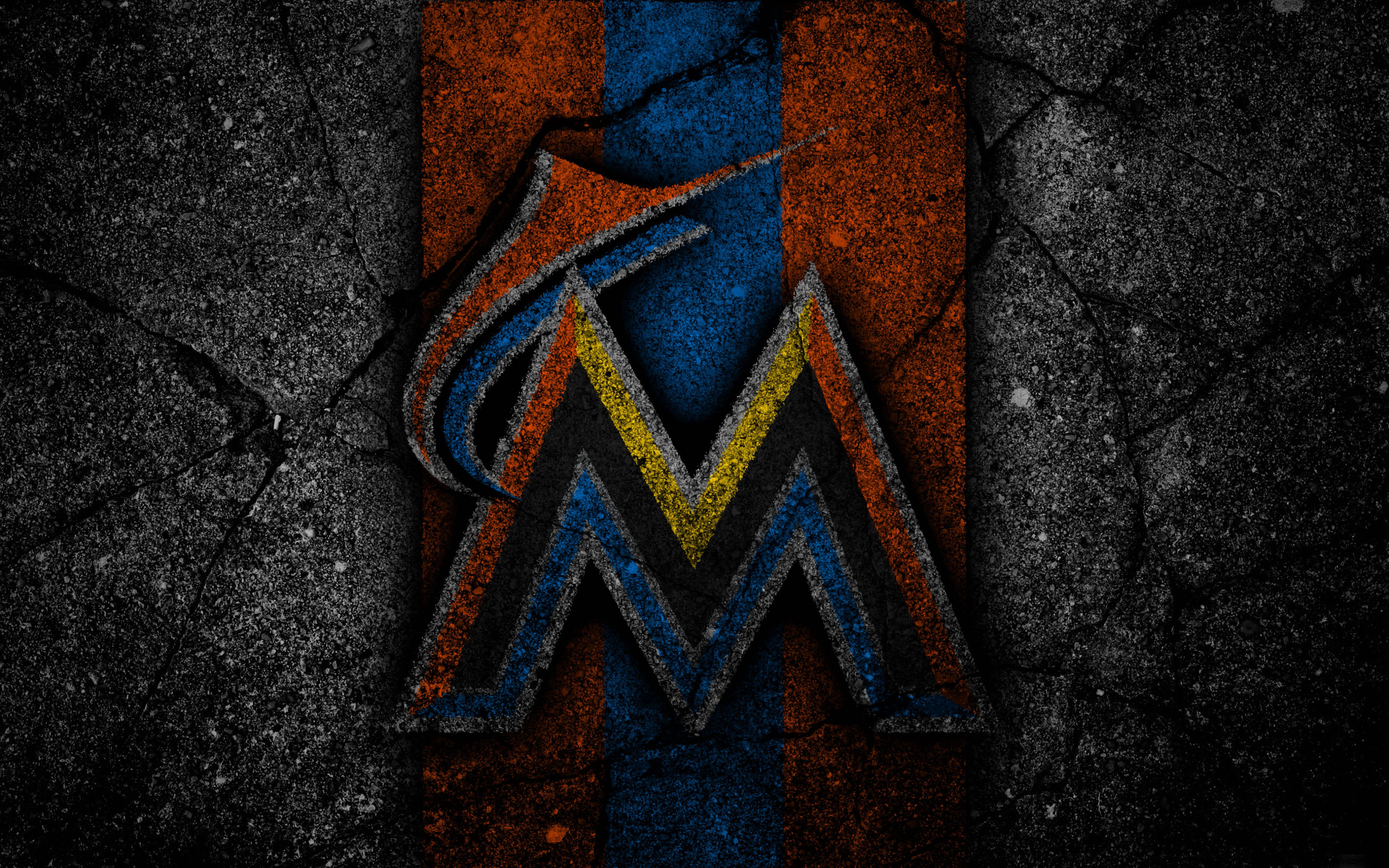 Marlins 桌布 壁紙 — 一個經過風化的邁阿密馬林魚標誌，帶有橙色、藍色和黃色條紋，背景是裂開的瀝青路面。