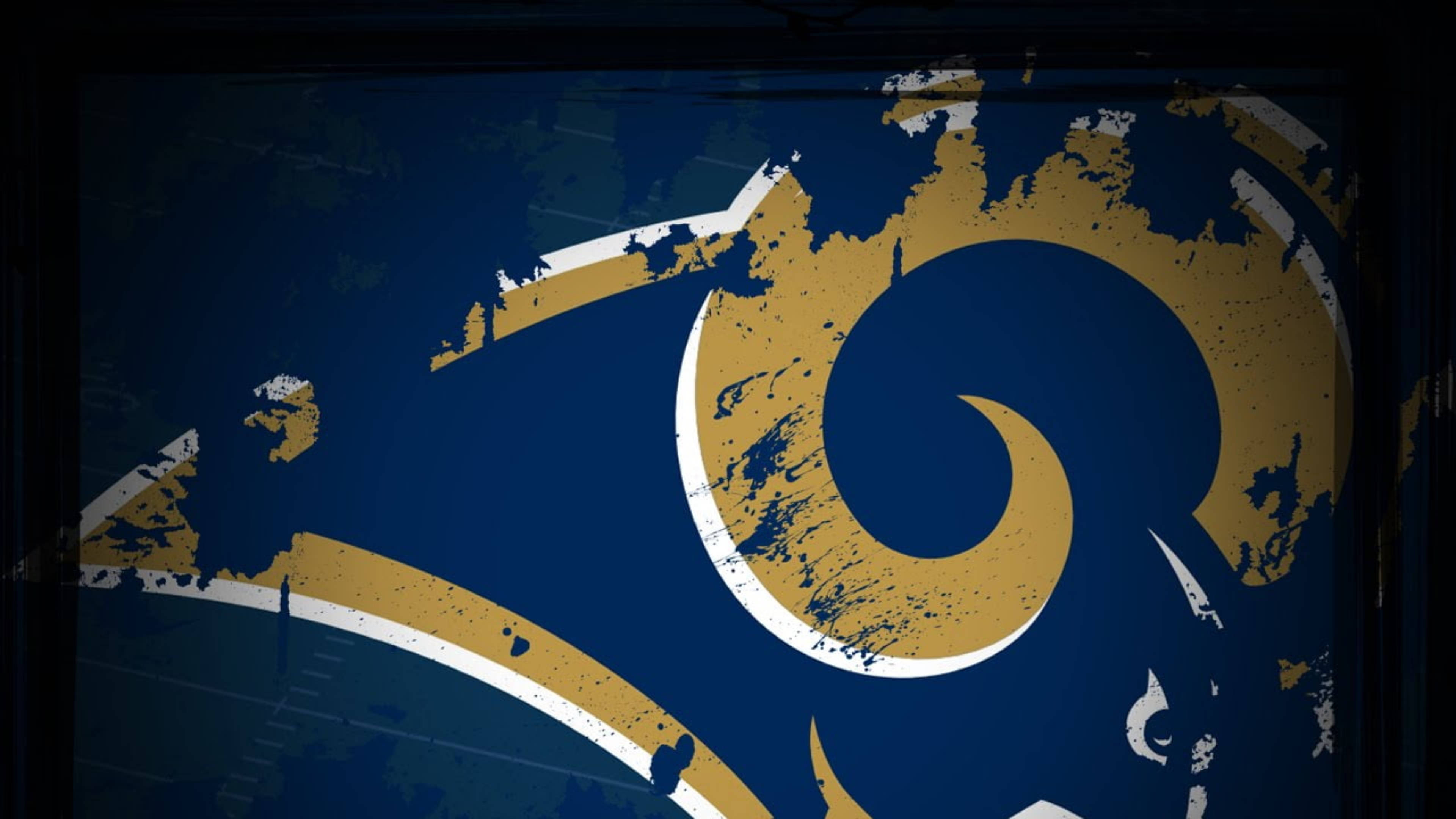 Rams 桌布 壁紙 — 一個經風化的藍色和金色公羊標誌，帶有白色邊框，在深色背景上顯示可見的油漆飛濺和剝落紋理。