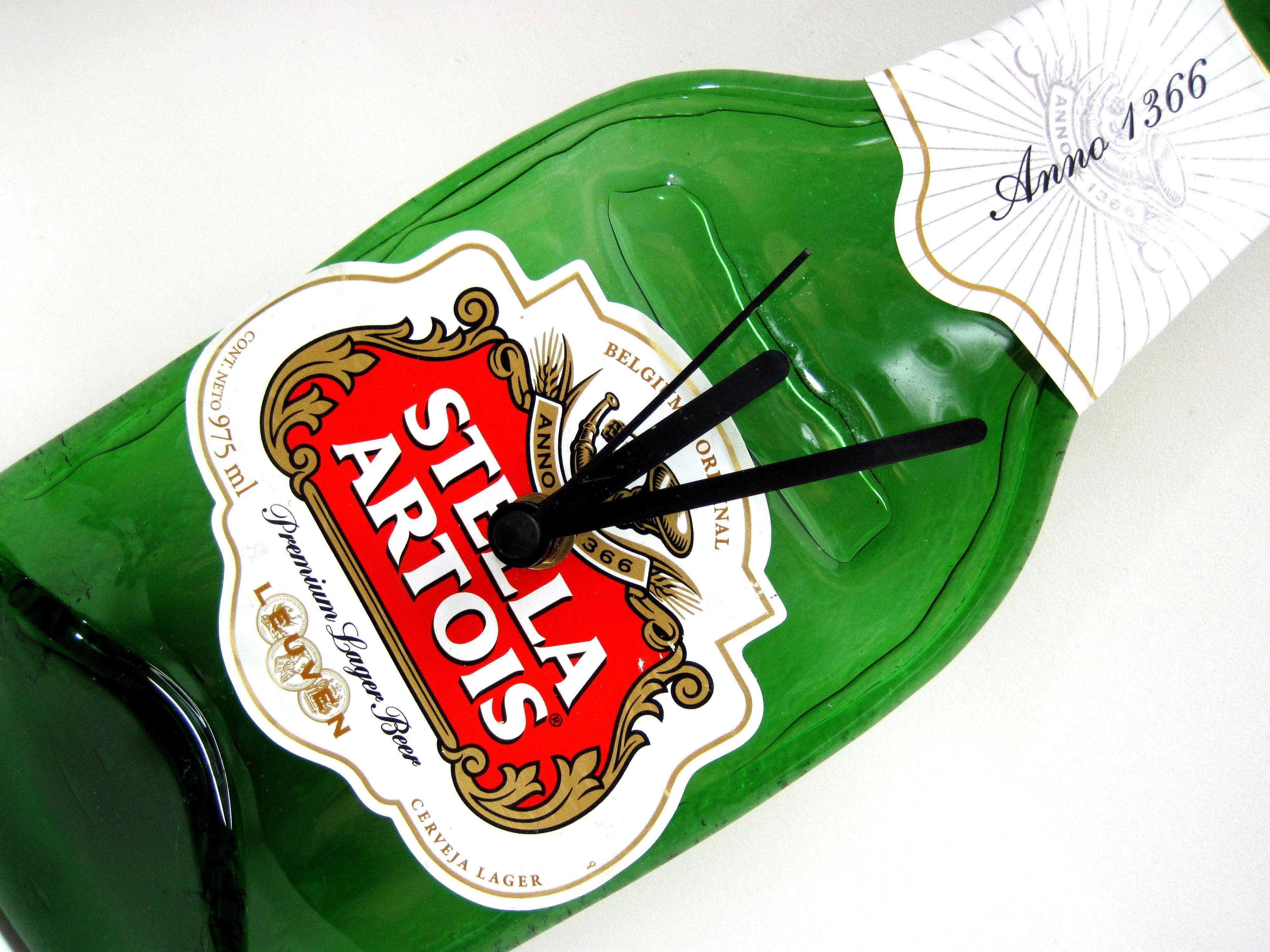 飲料 桌布 壁紙 — 一個綠色Stella Artois啤酒瓶被重新用作掛牆鐘，帶有黑色指針，背景為白色。