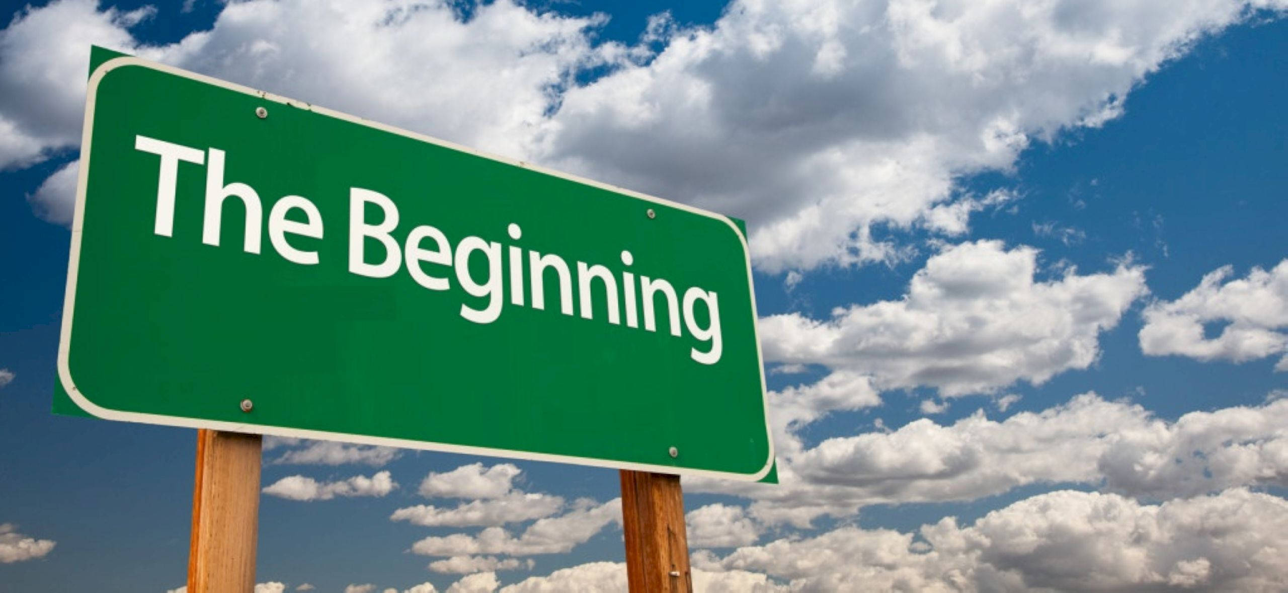雲朵 桌布 壁紙 — 一個綠色的路牌寫著「The Beginning」，在充滿蓬鬆白雲的明亮藍天下矗立。