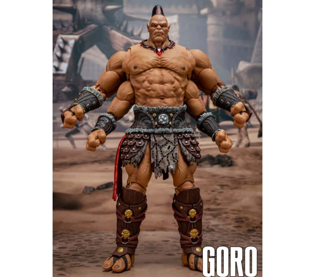 Mortal Kombat Goro 桌布 壁紙 — 一個綠色皮膚、肌肉發達的戰士，留著尖刺的莫西干頭，站在沙漠荒地中，穿著部落盔甲和涼鞋。
