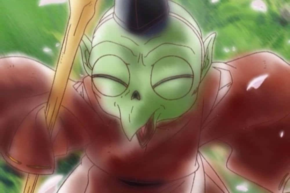 Inuyasha Jaken 桌布 壁紙 — 一個綠色皮膚的動漫角色，閉著眼睛，黑色髮髻，在模糊的綠色背景前微笑著拿著法杖。