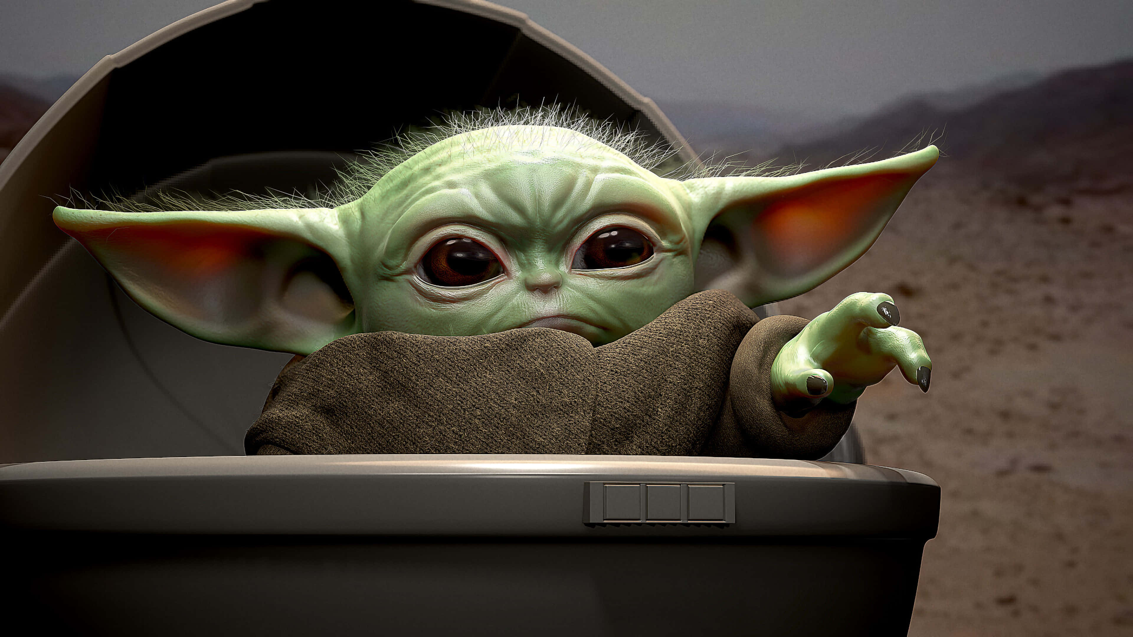 Baby Yoda Cartoon 桌布 壁紙 — 一個綠色皮膚的嬰兒尤達從太空船艙中好奇地窺視，背景是貧瘠的沙漠景觀。