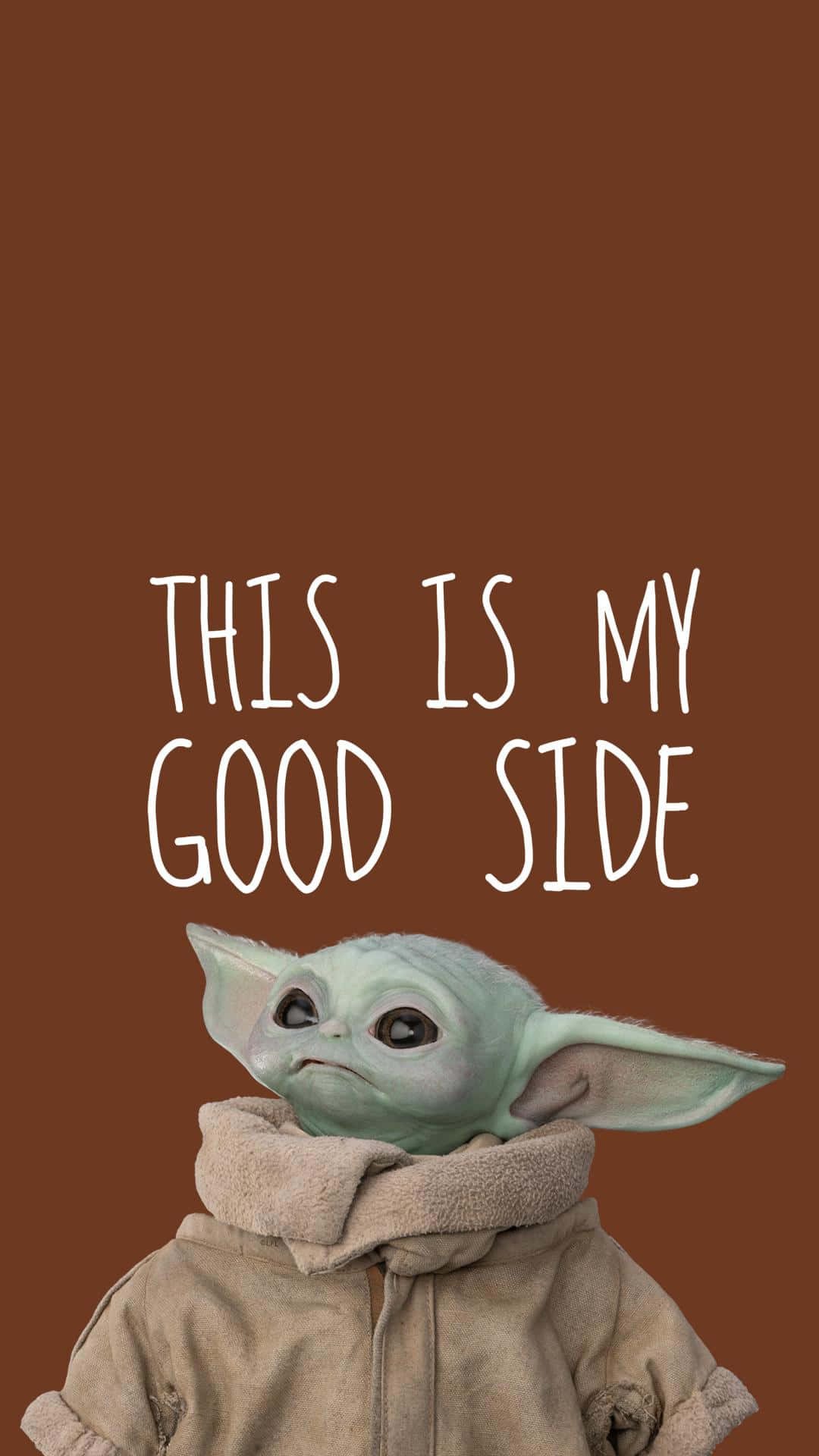 Baby Yoda iPhone 桌布 壁紙 — 一個綠色皮膚的嬰兒尤達穿著米色連帽衫，在純棕色背景上抬頭露出甜美表情，上面有白色文字寫著'THIS IS MY GOOD SIDE'。