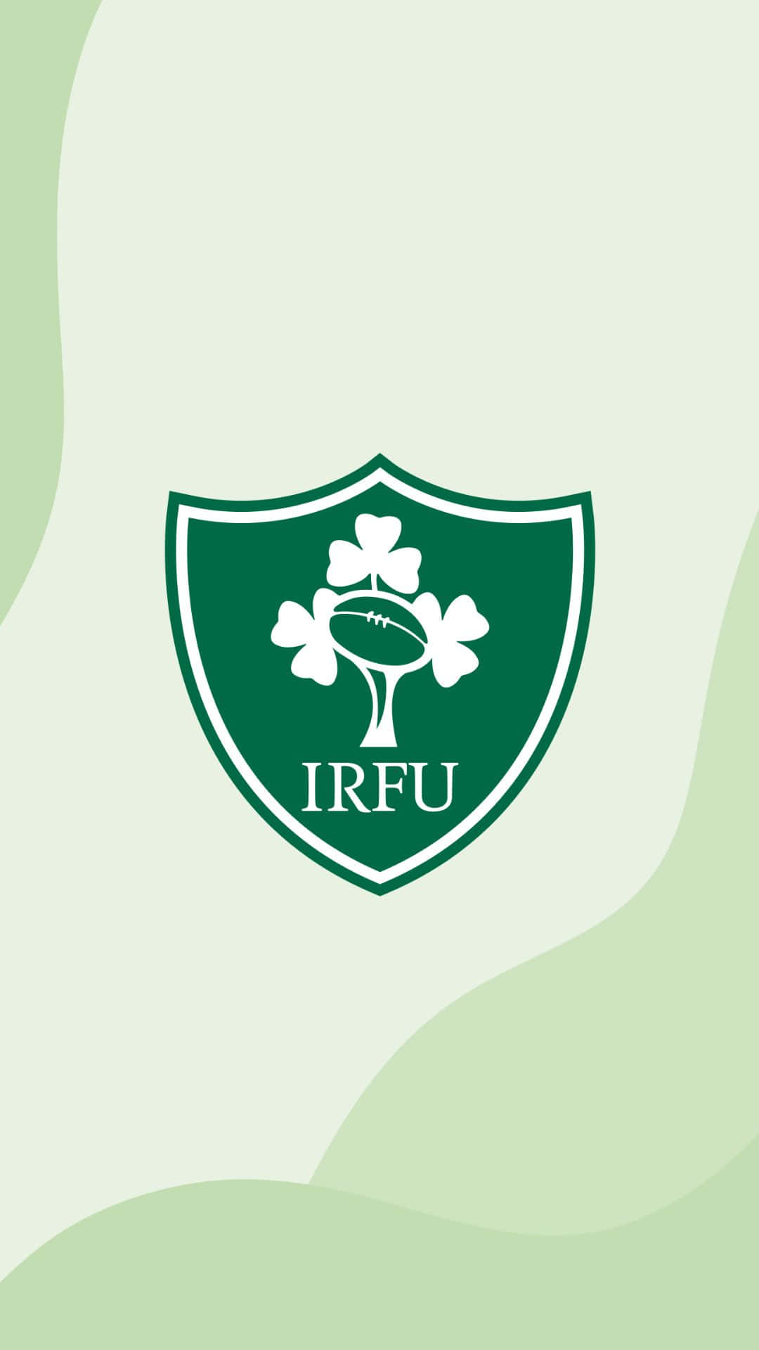 Ireland Rugby 桌布 壁紙 — 一個綠色盾牌標誌，中央有白色三葉草和橄欖球，置於柔和的漸變綠色背景上。