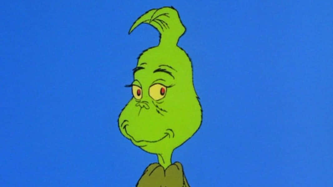 Grinch Zoom 桌布 壁紙 — 一個綠色聖誕怪傑，紅色眼睛，咧嘴笑，背景為純藍色。