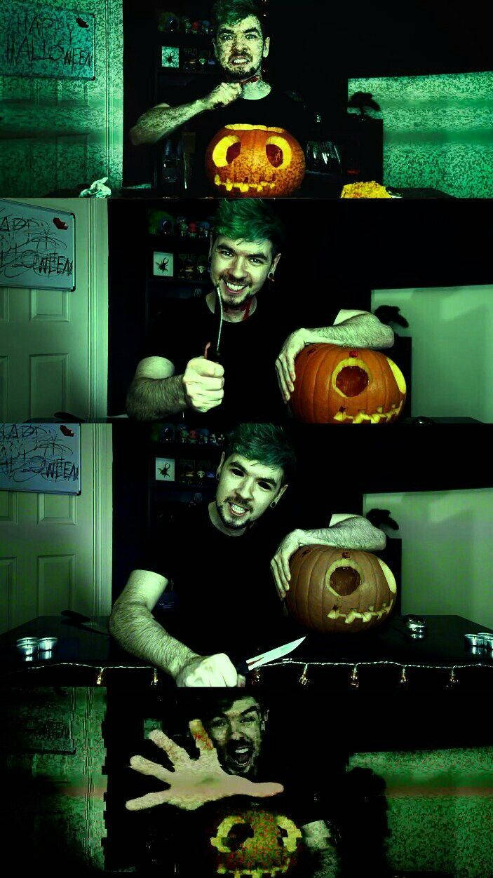 Jacksepticeye 桌布 壁紙 — 一個綠髮男子在昏暗的房間裡雕刻南瓜，房間有萬聖節裝飾和綠色燈光。