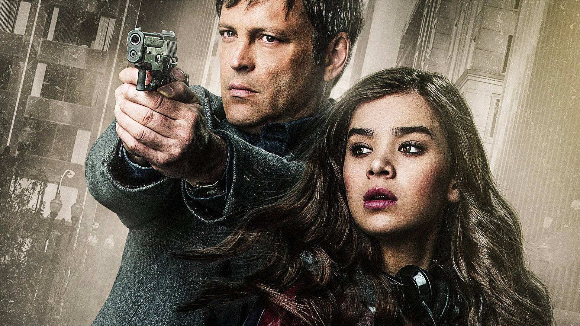 Hailee Steinfeld 桌布 壁紙 — 一個緊張的動作場景，一名男子瞄準手槍，而一名年輕女子在粗糙的城市背景下睜大眼睛看著。