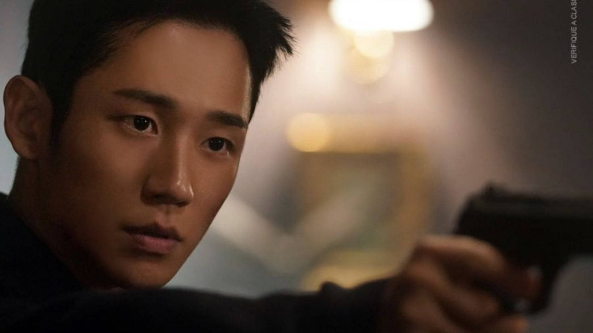 drama 桌布 壁紙 — 一個緊張的特寫鏡頭，一個男人在昏暗的房間裡專注地握著手槍。