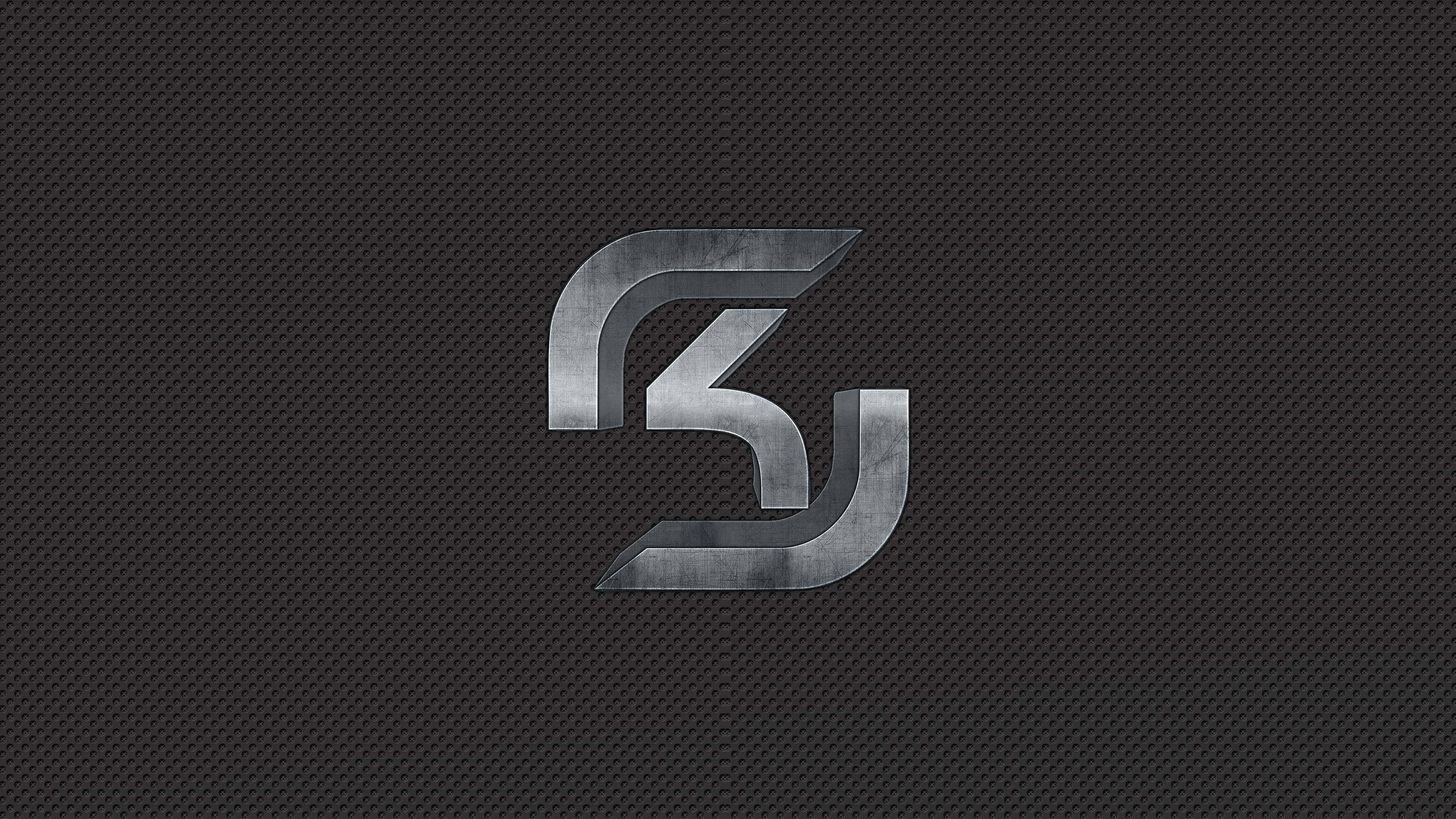 Sk Gaming 桌布 壁紙 — 一個線條銳利的時尚金屬標誌，在深色碳纖維紋理背景上微微發光。