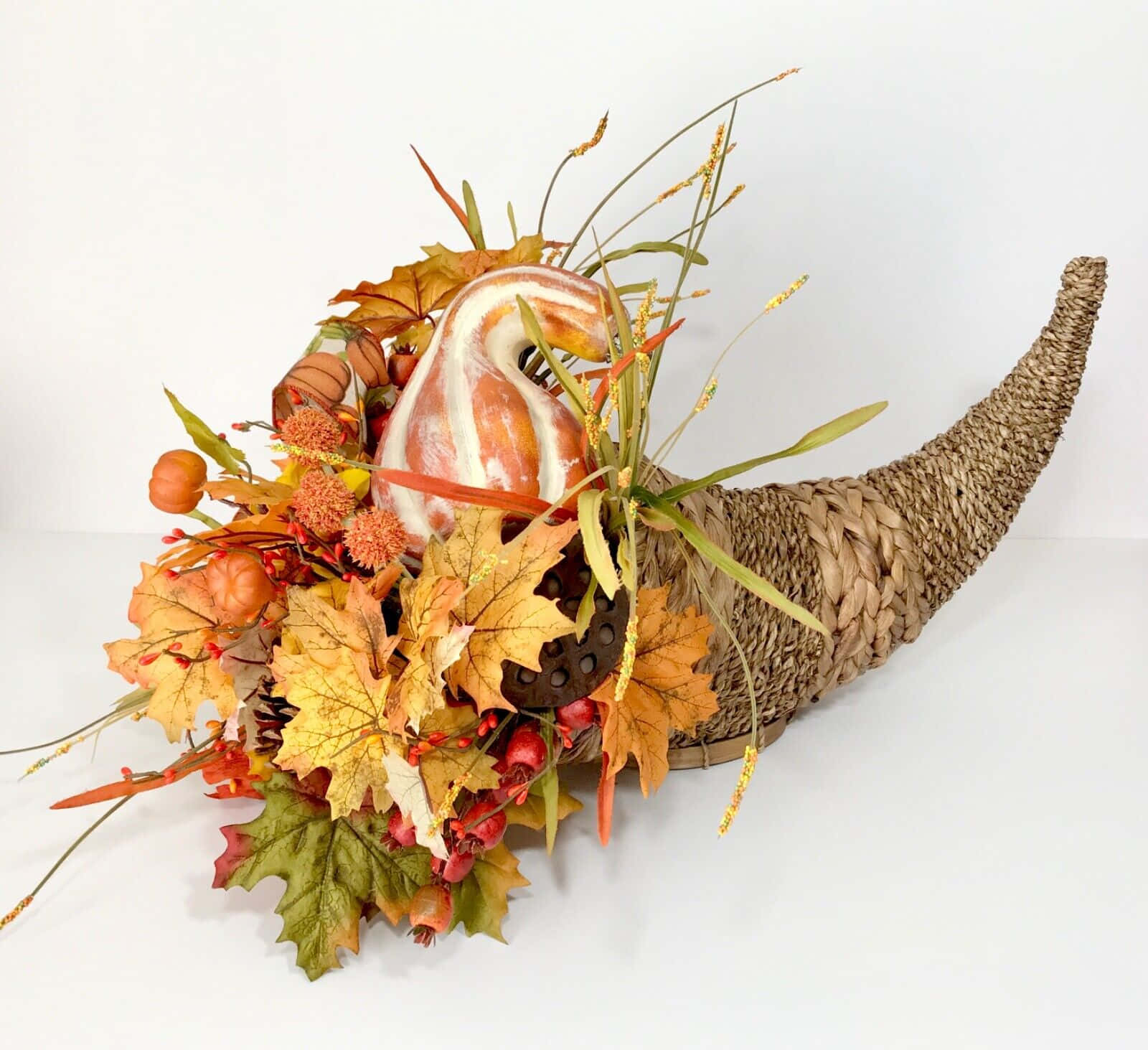 Fall Cornucopia 桌布 壁紙 — 一個編織的豐饒角，裝滿了秋葉、南瓜、漿果和草，襯著白色背景。