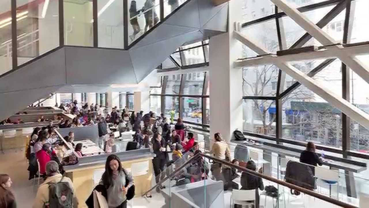 Eating 桌布 壁紙 — 一個繁忙的現代圖書館，人們在玻璃幕牆的中庭和多層樓梯間學習和走動。