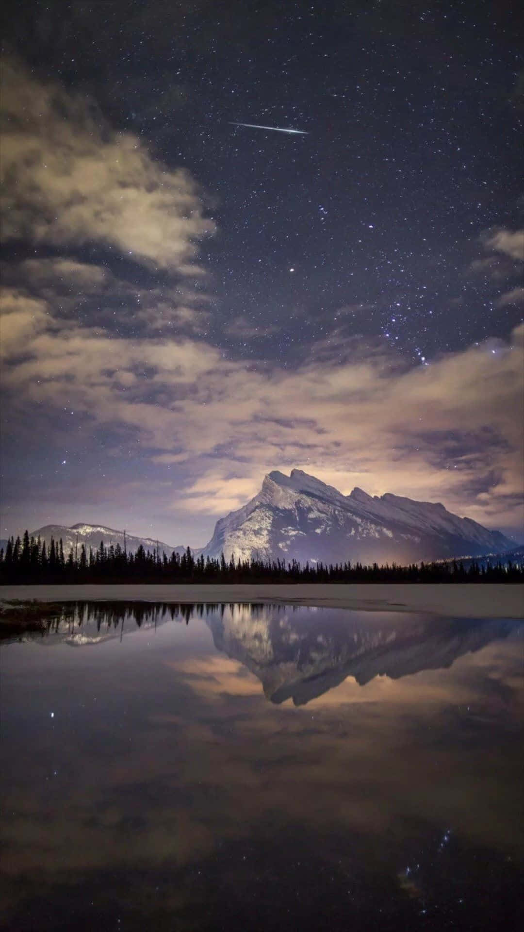 Lake 桌布 壁紙 — 一個繁星點點的夜空，一顆流星劃過積雪的山峰，倒映在平靜的湖面上。