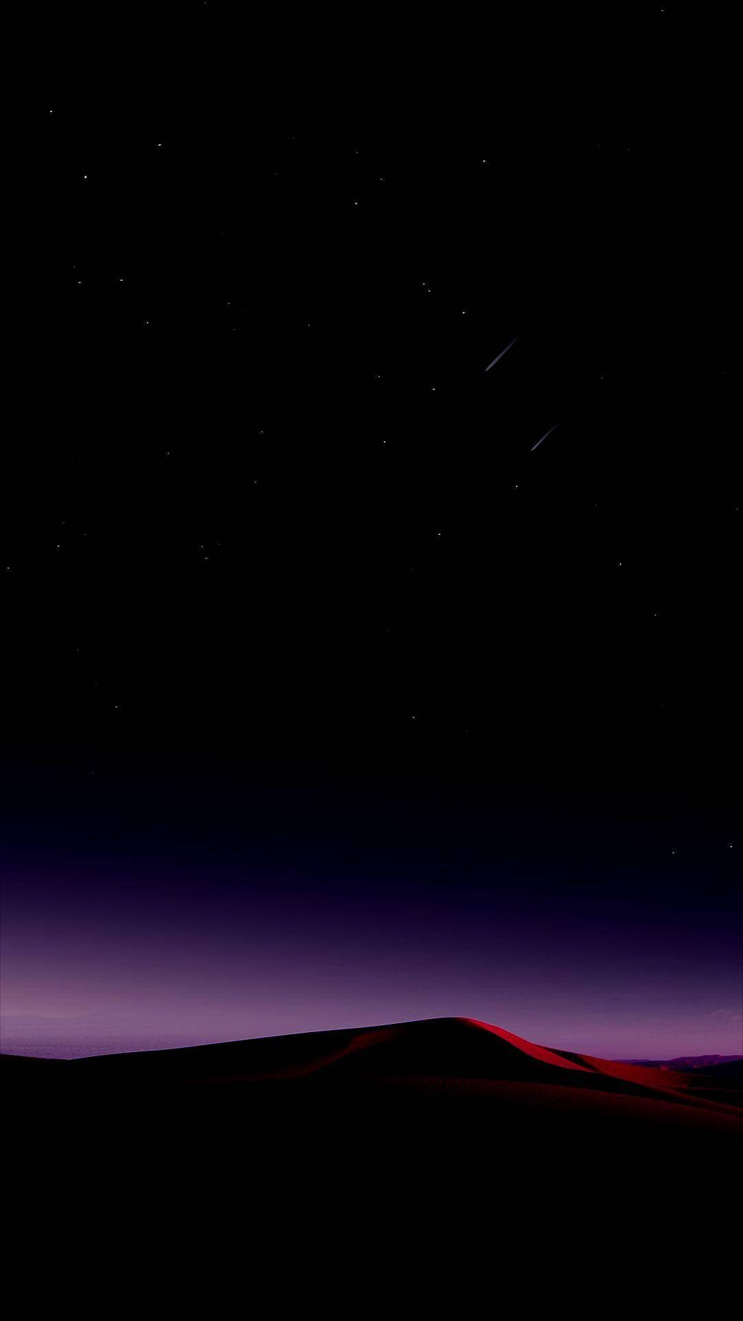 手機 桌布 壁紙 — 一個繁星點點的夜空，兩顆流星劃過剪影的沙漠沙丘，在黃昏時散發出紫色和紅色的光芒。