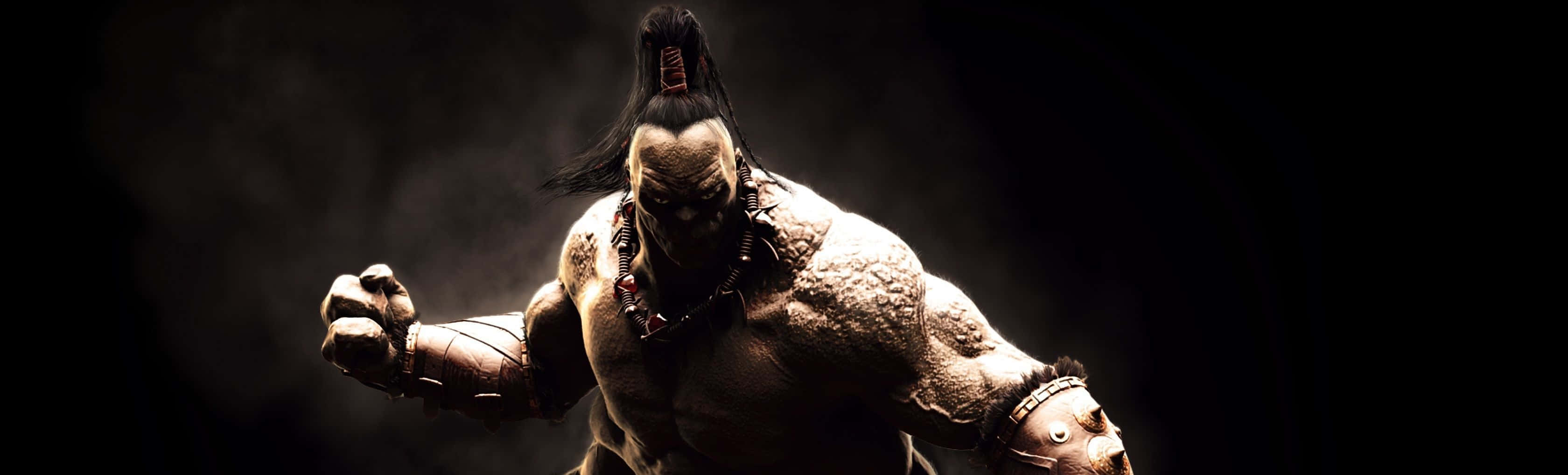 Mortal Kombat Goro 桌布 壁紙 — 一個肌肉發達、帶有部落紋身和莫霍克頭的戰士，站在黑暗煙霧繚繞的環境中，燈光效果戲劇化。