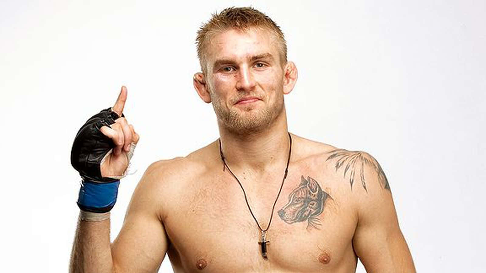 UFC 桌布 壁紙 — 一個肌肉發達、有刺青、戴著拳擊手套的男人，在純白色背景上指向上面。
