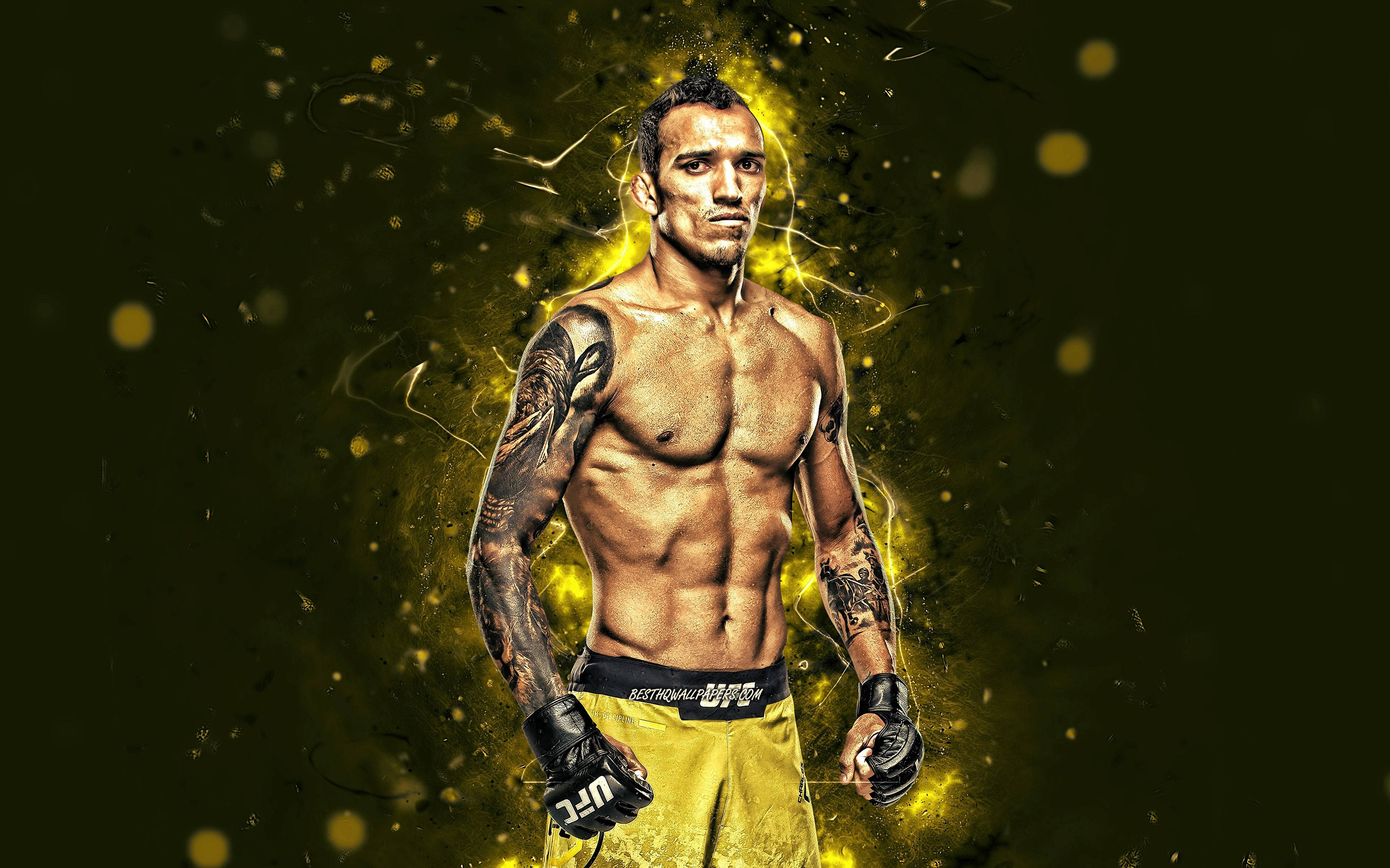 MMA 桌布 壁紙 — 一個肌肉發達、有刺青的拳擊手，穿著黃色短褲和手套，站在發光的金色粒子背景前。