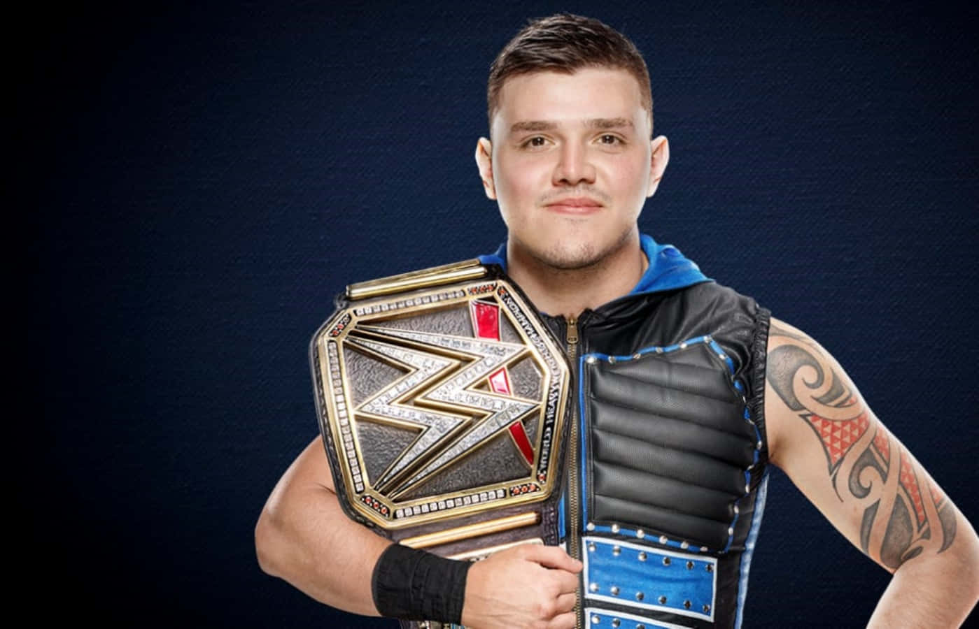 WWE 桌布 壁紙 — 一個肌肉發達、有刺青的摔角手，在深色紋理背景前舉起閃亮的冠軍腰帶。