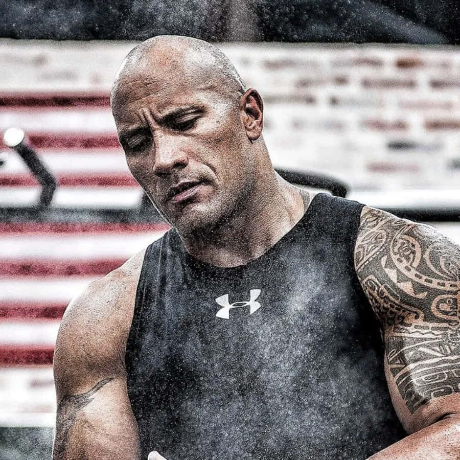 Under Armour 桌布 壁紙 — 一個肌肉發達、紋身和臉上流汗的男人，在美國國旗背景的健身房中表情強烈。