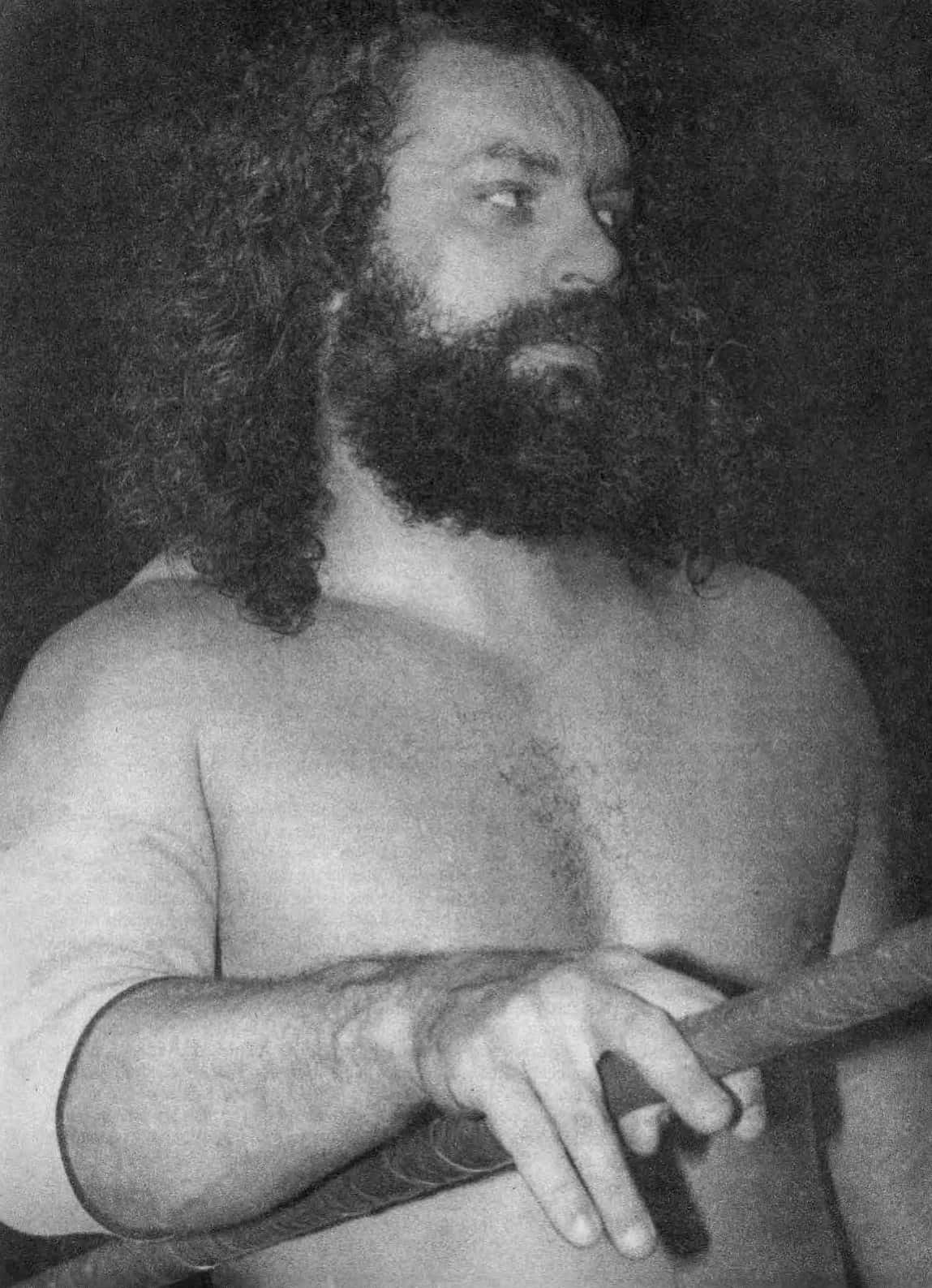 WWE 桌布 壁紙 — 一個肌肉發達、長捲髮、濃鬍鬚的男人，在黑白肖像中握著繩索。
