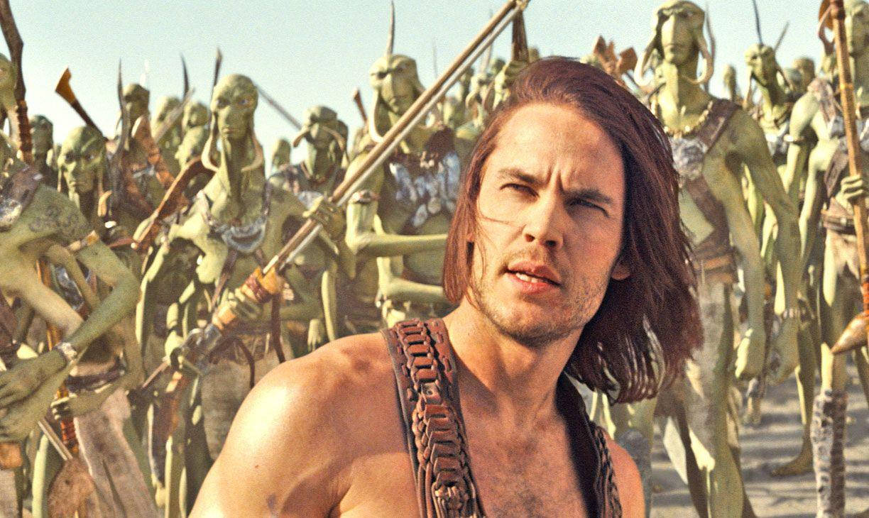 john carter 桌布 壁紙 — 一個肌肉發達、長著棕色長髮的男人挑釁地直視前方，身後是一群手持長矛的綠色皮膚戰士。