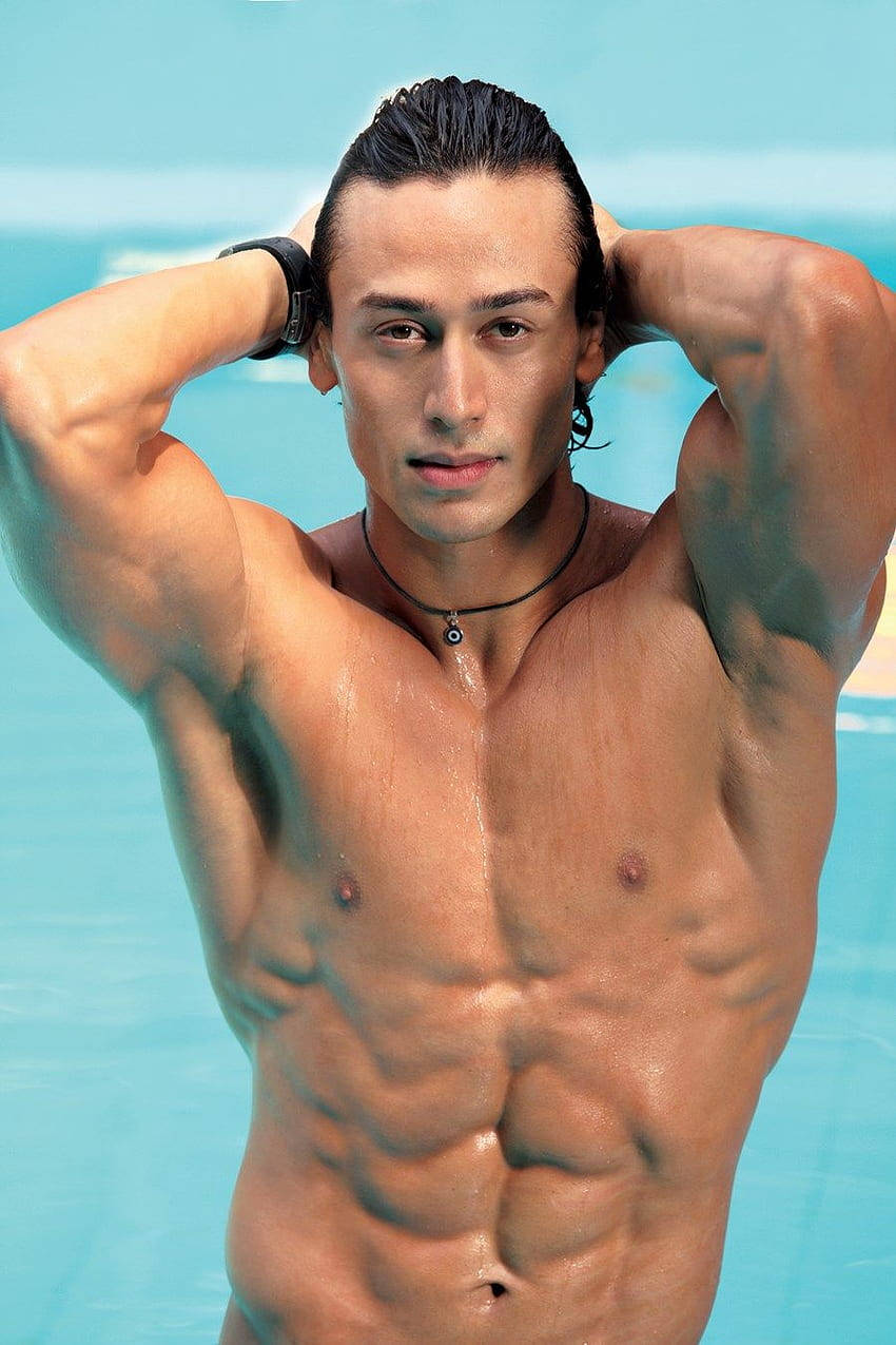 Indian 桌布 壁紙 — 一個肌肉發達、頭髮濕透的男人站在藍綠色的泳池中，雙手放在腦後，直視鏡頭。