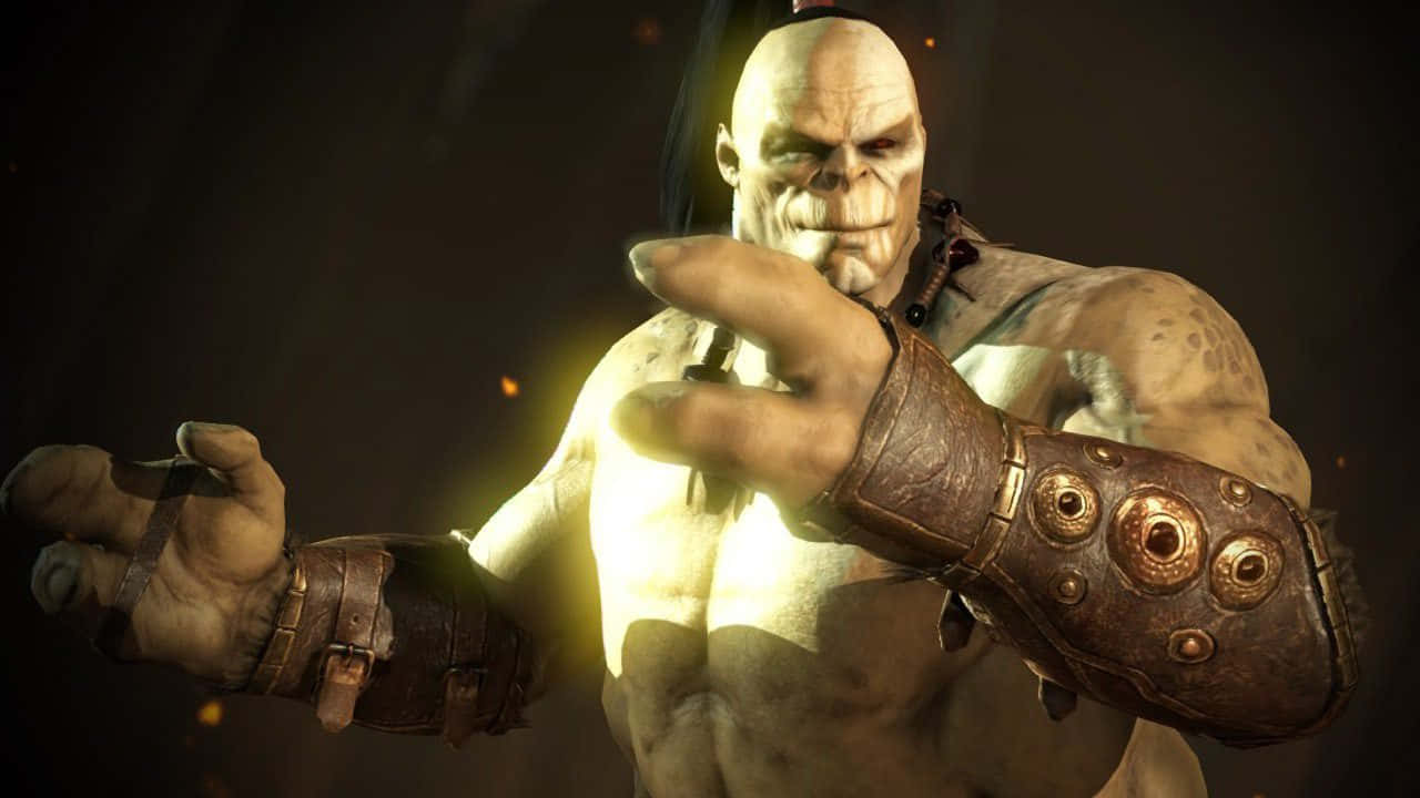 Mortal Kombat Goro 桌布 壁紙 — 一個肌肉發達的光頭戰士，雙手發光，戴著皮革護腕，站在黑暗的競技場中，散發出強大的力量。