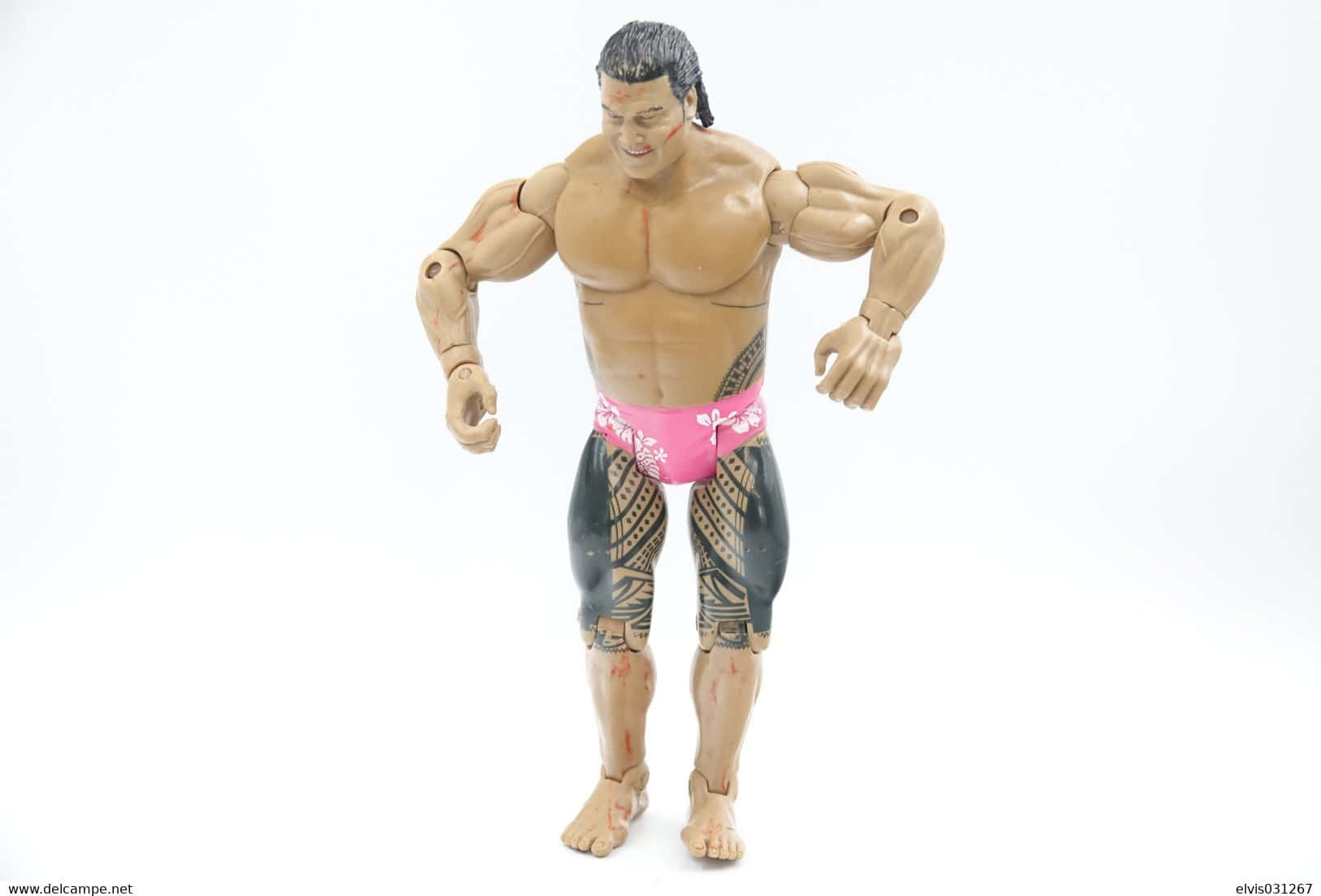 Peter Maivia 桌布 壁紙 — 一個肌肉發達的動作人偶，帶有部落紋身和粉紅色花卉短褲，站在純白色背景前。