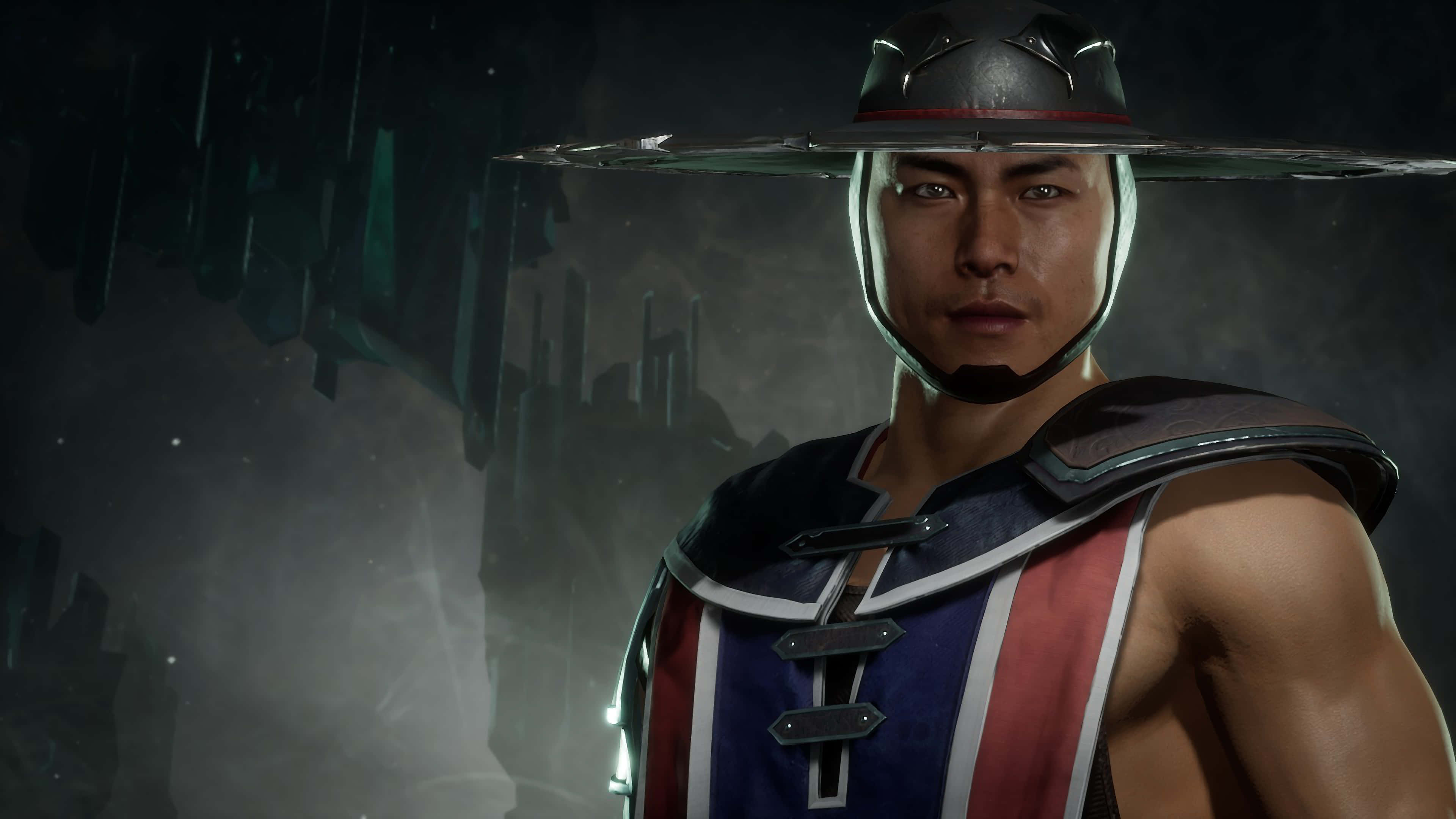 Mortal Kombat Kung Lao 桌布 壁紙 — 一個肌肉發達的戰士，戴著寬邊帽，身穿紅藍白盔甲，站在迷霧籠罩的黑暗城市廢墟中。