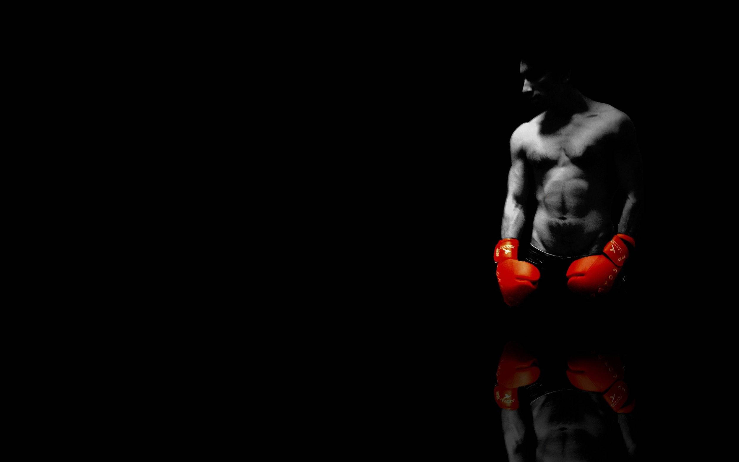 Boxing 桌布 壁紙 — 一個肌肉發達的拳擊手戴著紅色手套，站在陰影黑暗中，下方有反射表面。