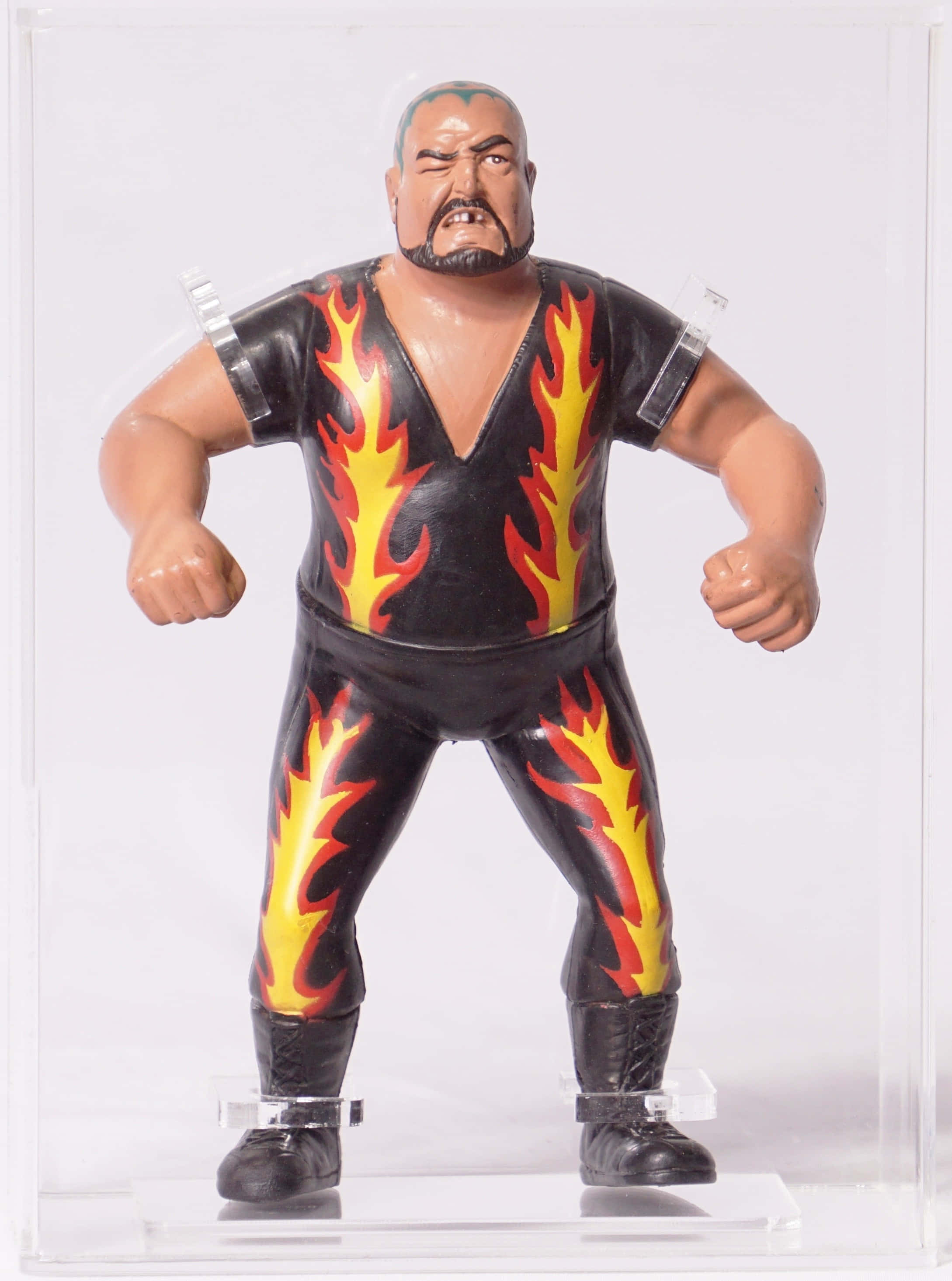 WWE 桌布 壁紙 — 一個肌肉發達的摔角手動作人偶，身穿黑色火焰圖案服裝，在透明展示櫃內擺出戰鬥姿勢。