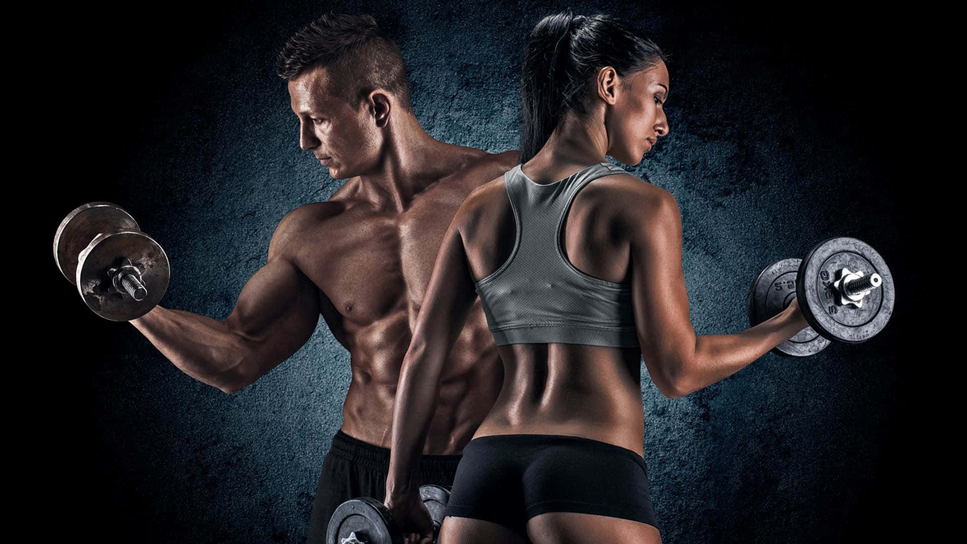Fitness 桌布 壁紙 — 一個肌肉發達的男人和女人背對背站立，在戲劇性燈光下對著深色紋理牆壁舉起啞鈴。