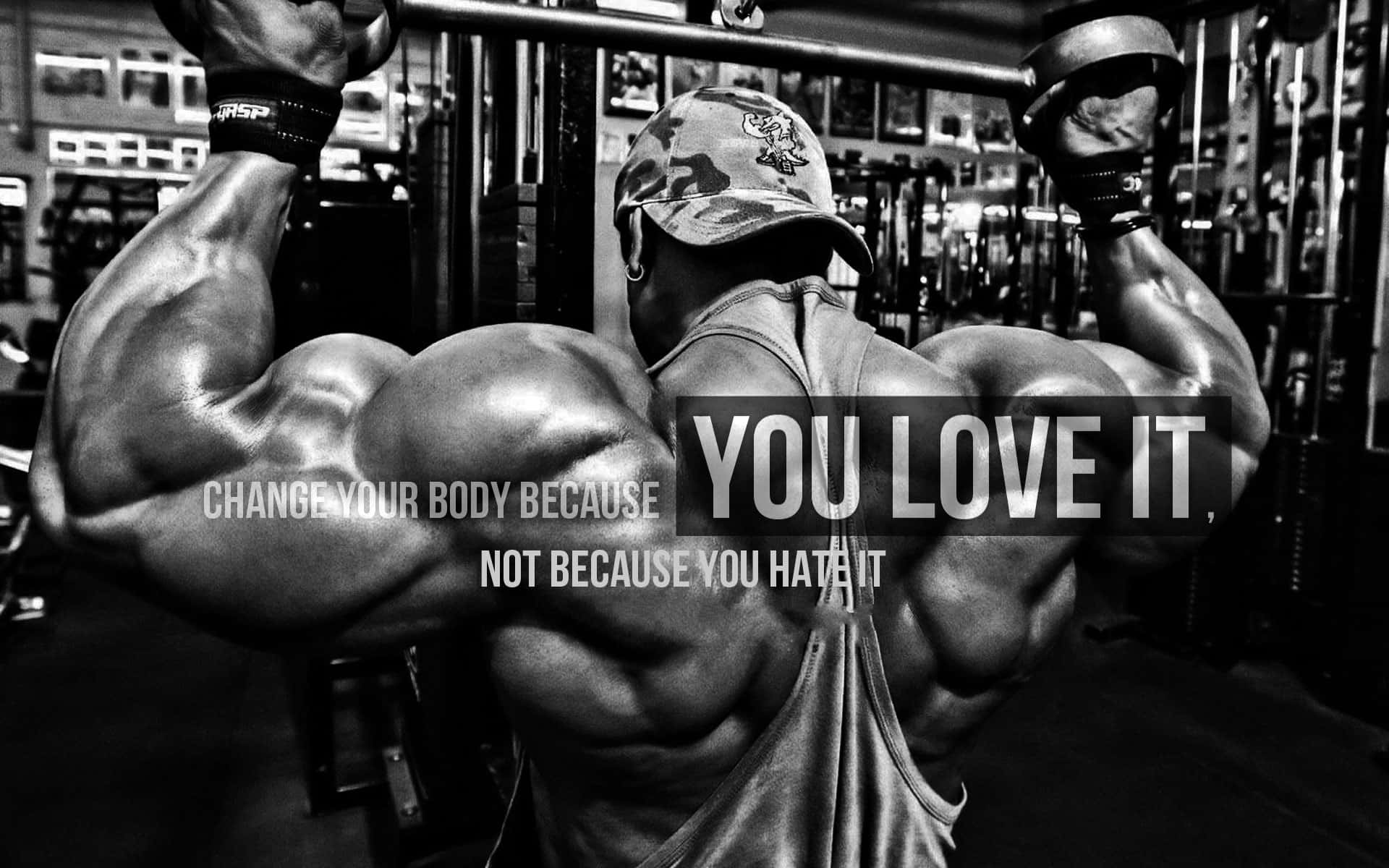 bodybuilding 桌布 壁紙 — 一個肌肉發達的男人在健身房裡拿著啞鈴，繃緊背部肌肉的黑白照片。